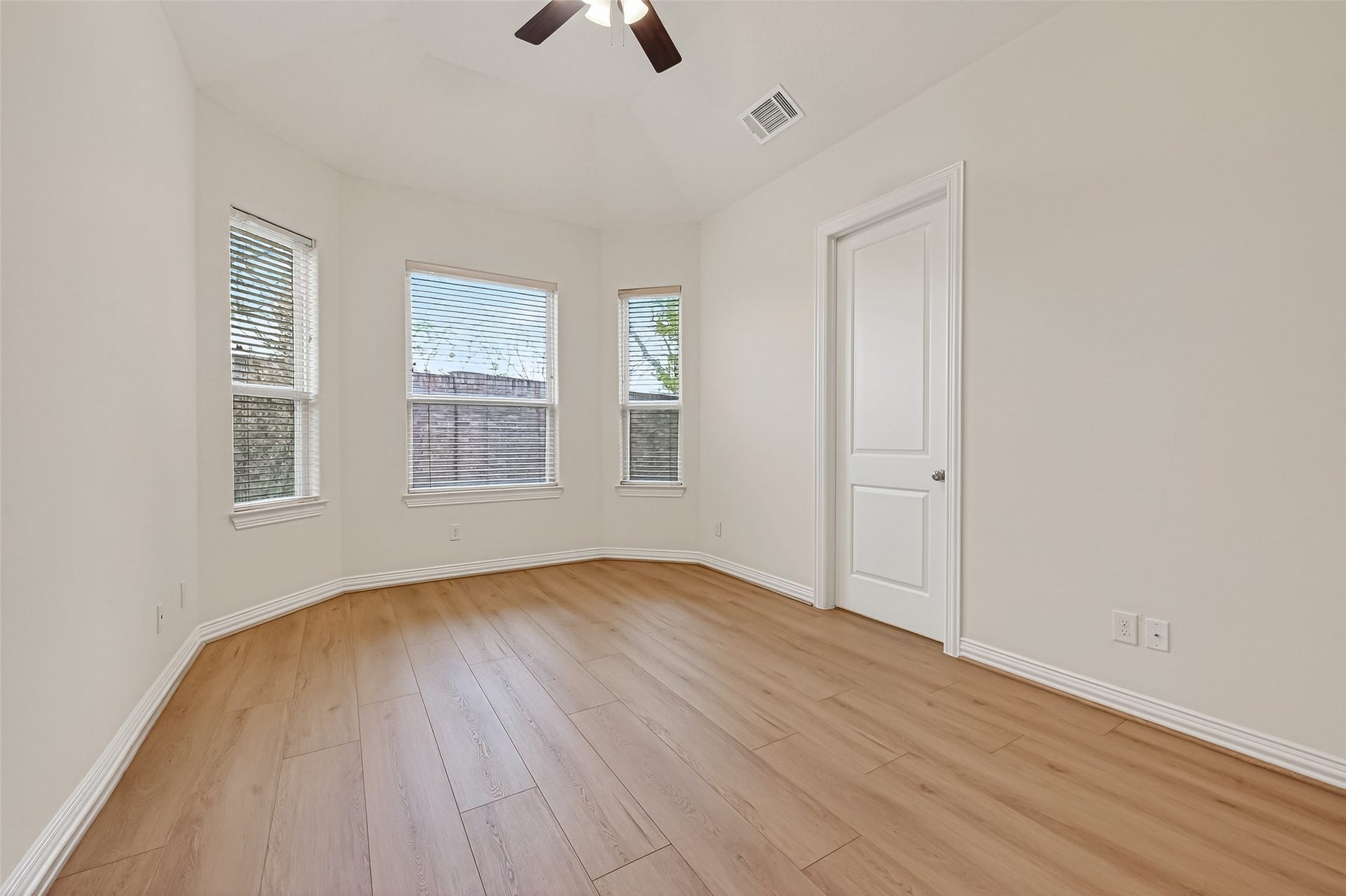 14447 KINGSTON COVE Lane, Houston, TX 77077 The downstairs secondary bedroom features high ceilings, a soft neutral palette, and abundant natural light. Large double-pane windows with plantation shutters frame beautiful views of the backyard, creating a bright and comfortable retreat.