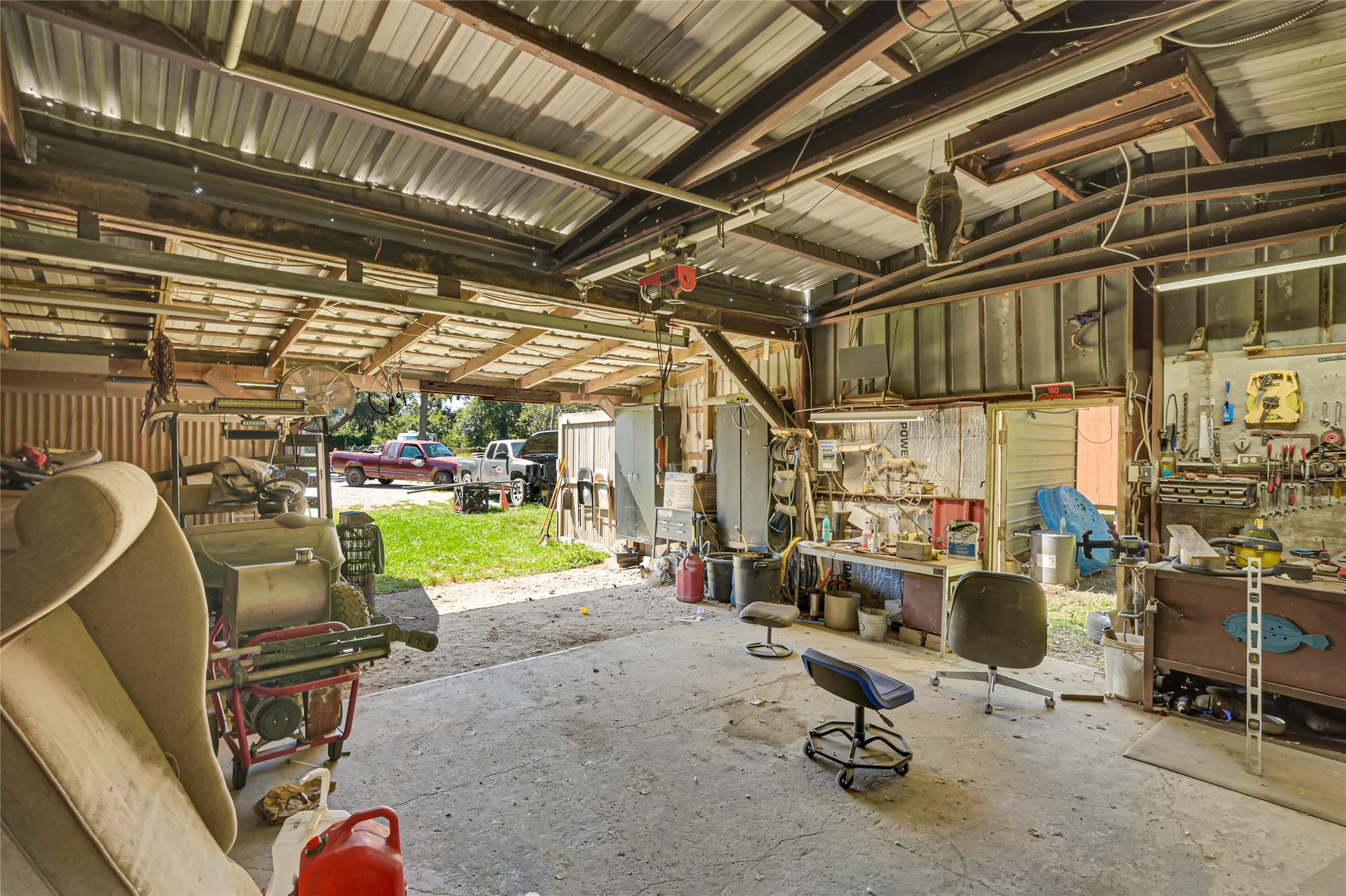 121 Patterson Road, #CR814, Brazoria, TX 77422 Spacious workshop with ample natural light, featuring a metal roof, workbench, and plenty of storage space for tools and equipment.