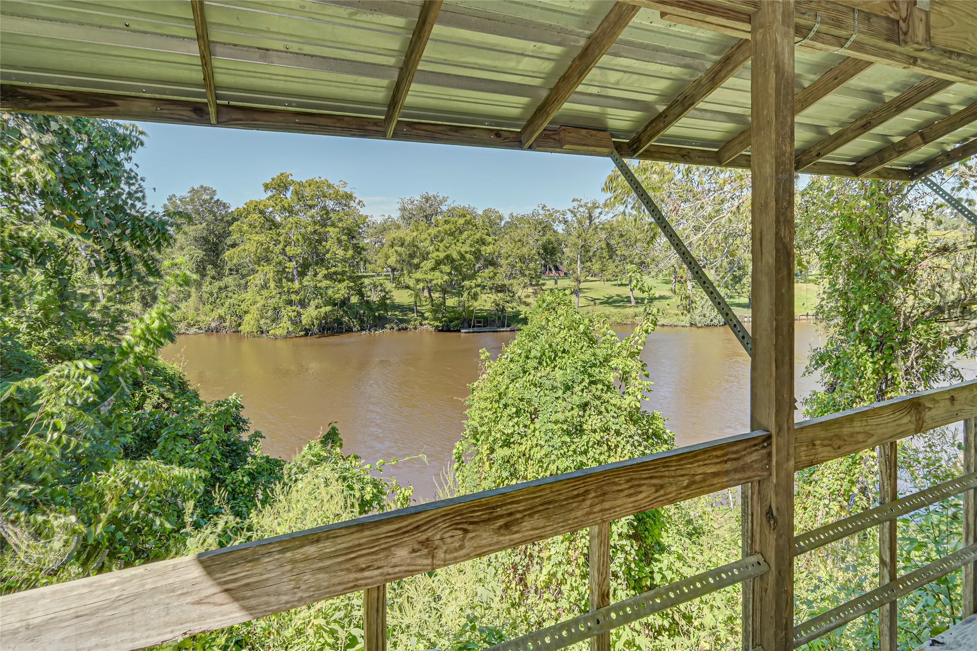 121 Patterson Road, #CR814, Brazoria, TX 77422 Enjoy serene river views from this charming covered balcony, surrounded by lush greenery for a perfect nature retreat.
