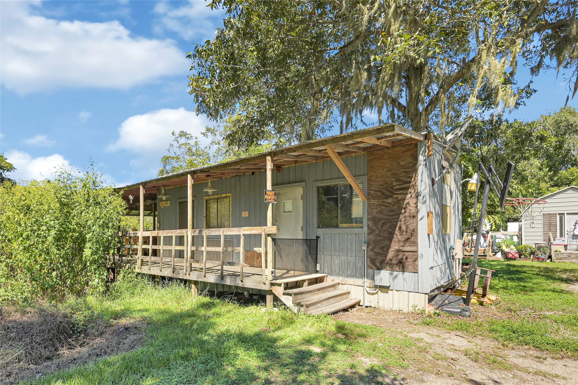 121 Patterson Road, #CR814, Brazoria, TX 77422 Charming rustic home with a covered porch set amidst lush greenery, offering a peaceful retreat.