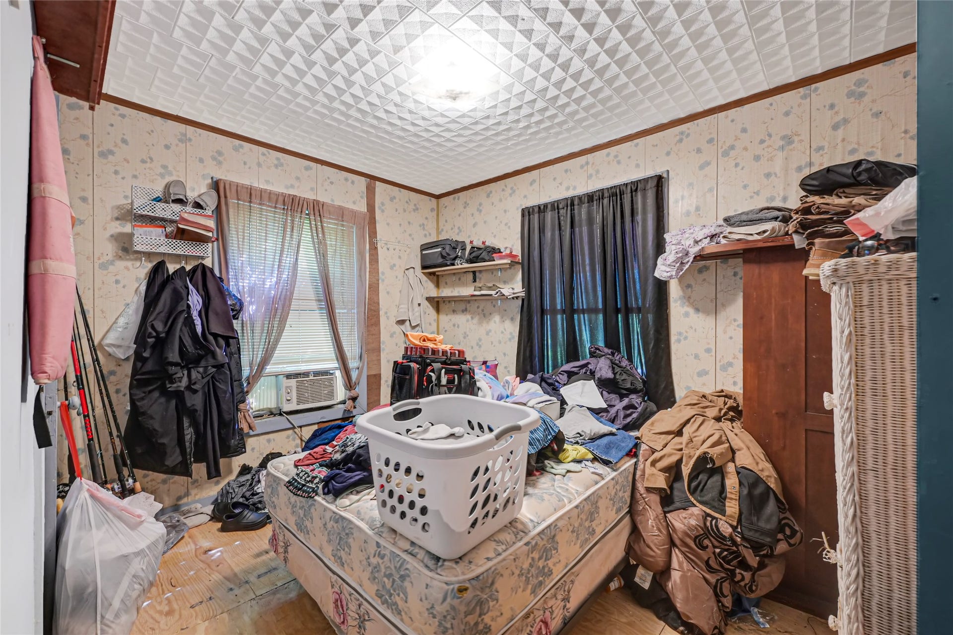 121 Patterson Road, #CR814, Brazoria, TX 77422 Cozy bedroom with potential, featuring textured ceilings and floral wallpaper. Ample natural light filters through dual windows, complemented by practical storage solutions. Ideal for personalization and creativity.