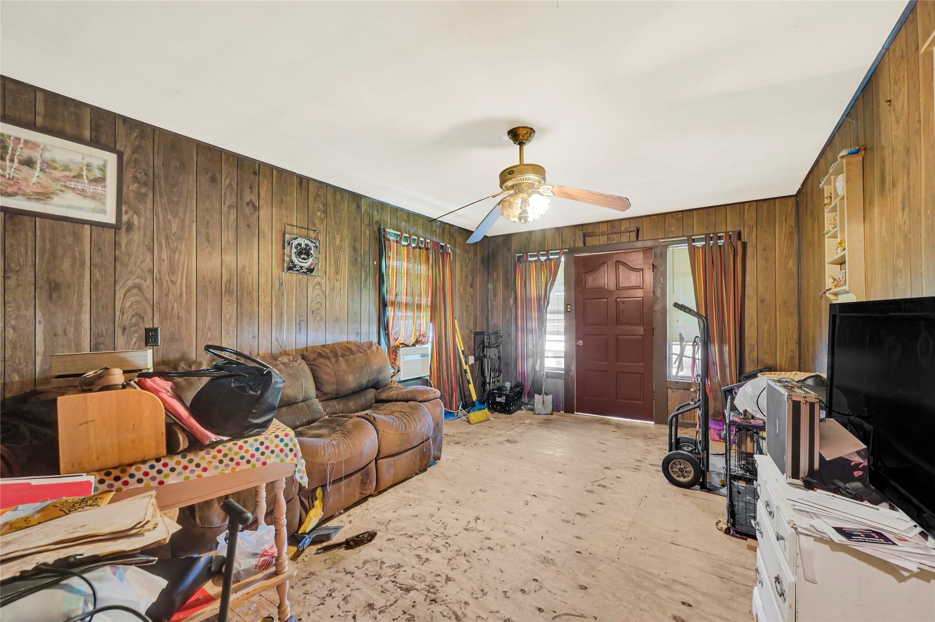 121 Patterson Road, #CR814, Brazoria, TX 77422 Cozy living area with wood paneling, ceiling fan, and potential for customization.