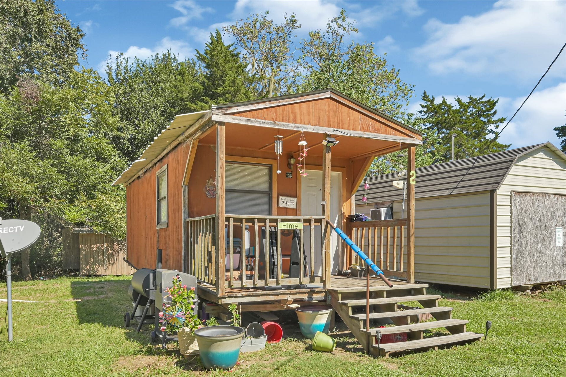 121 Patterson Road, #CR814, Brazoria, TX 77422 Charming small cabin with a cozy front porch, nestled in a lush, green setting. Ideal for a peaceful retreat.