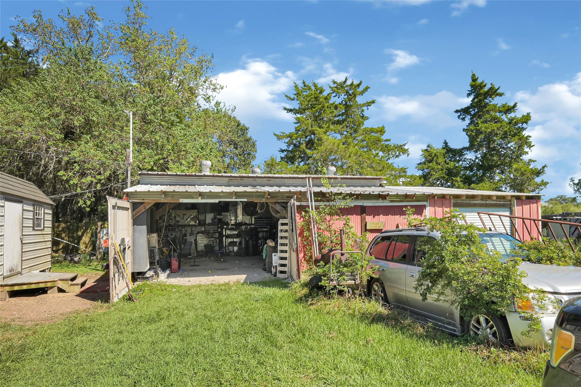 121 Patterson Road, #CR814, Brazoria, TX 77422 Spacious outdoor workshop with ample storage, surrounded by lush greenery and mature trees, perfect for projects and creativity.