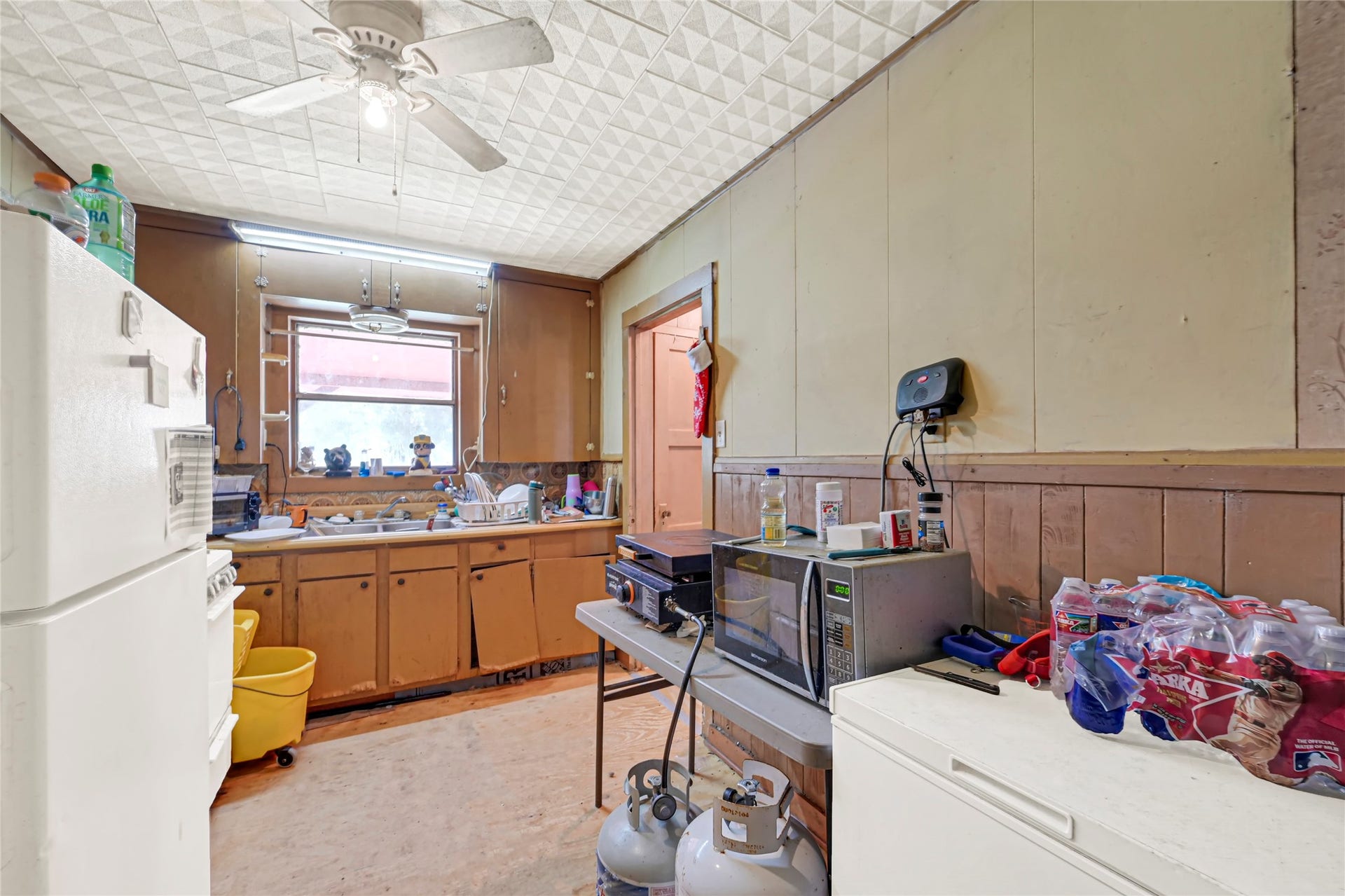 121 Patterson Road, #CR814, Brazoria, TX 77422 Cozy kitchen with rustic wooden cabinets, ample natural light, and a functional layout perfect for customization.