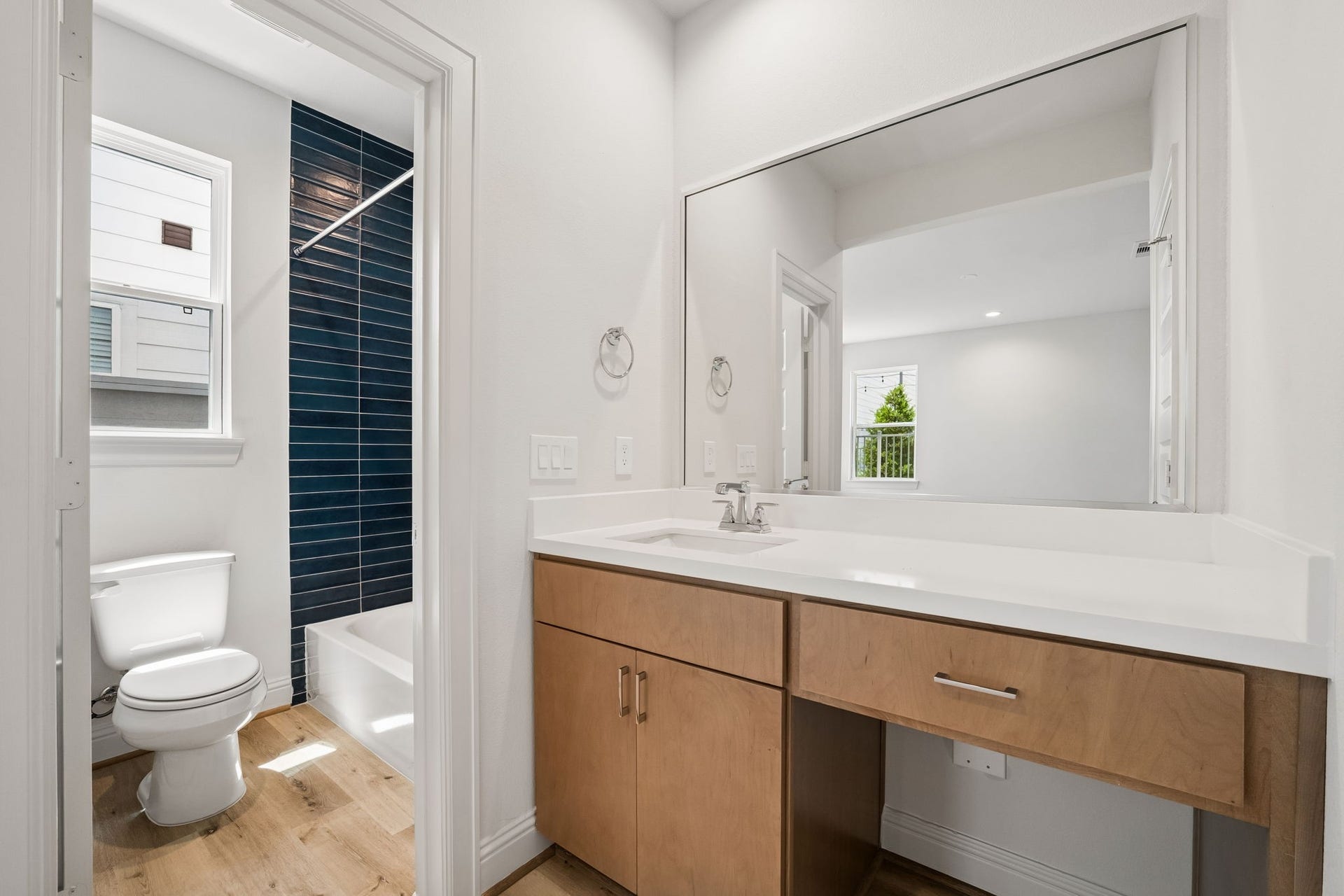Experience modern elegance in this first-floor bathroom, featuring a sleek vanity and a stylishly tiled shower area.