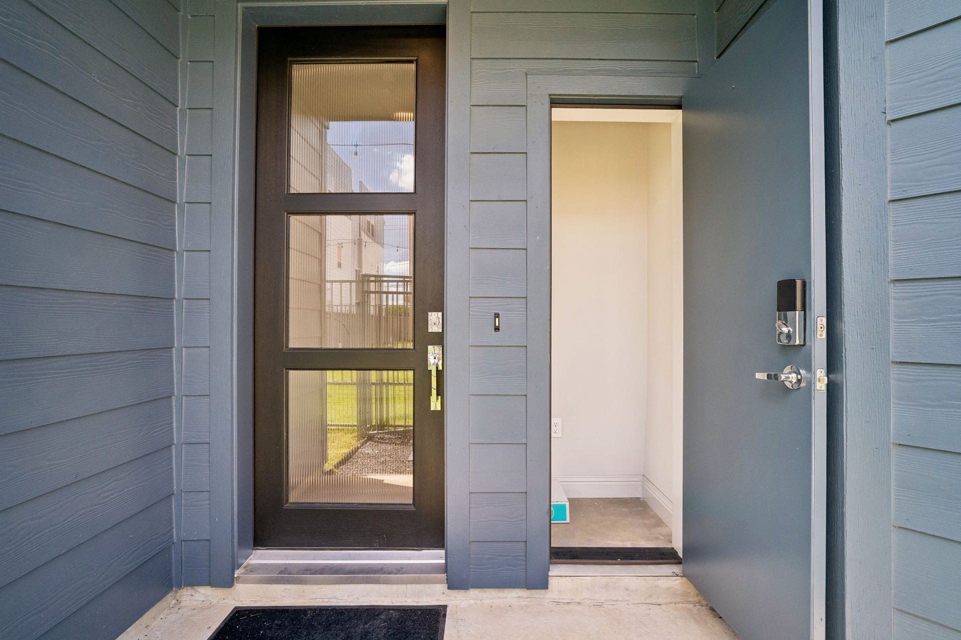 Step into modern elegance through a sleek front door, complemented by a convenient mail room for seamless living.