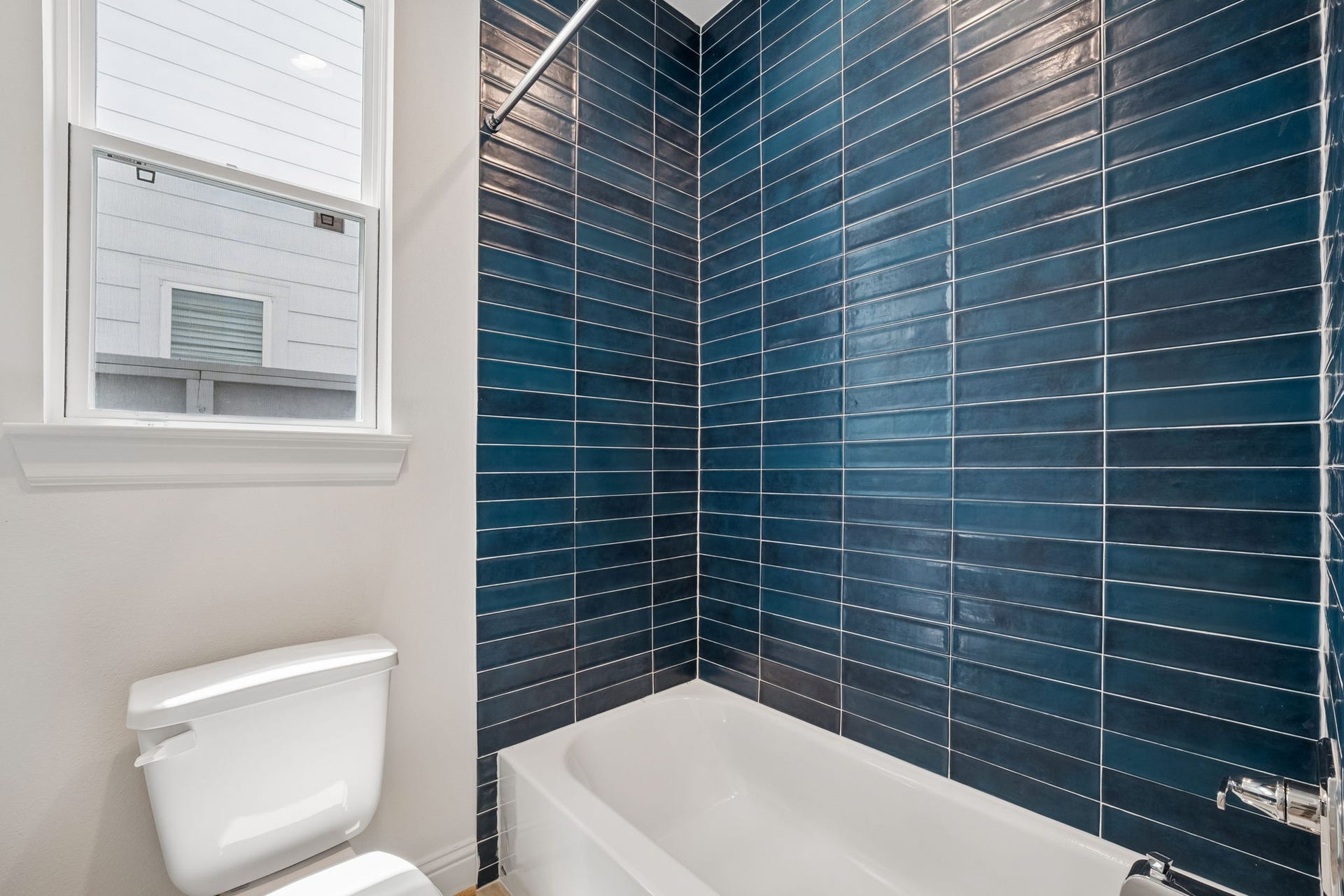 Experience modern elegance in the first-floor bathroom, featuring striking blue tiles that create a serene and stylish retreat.