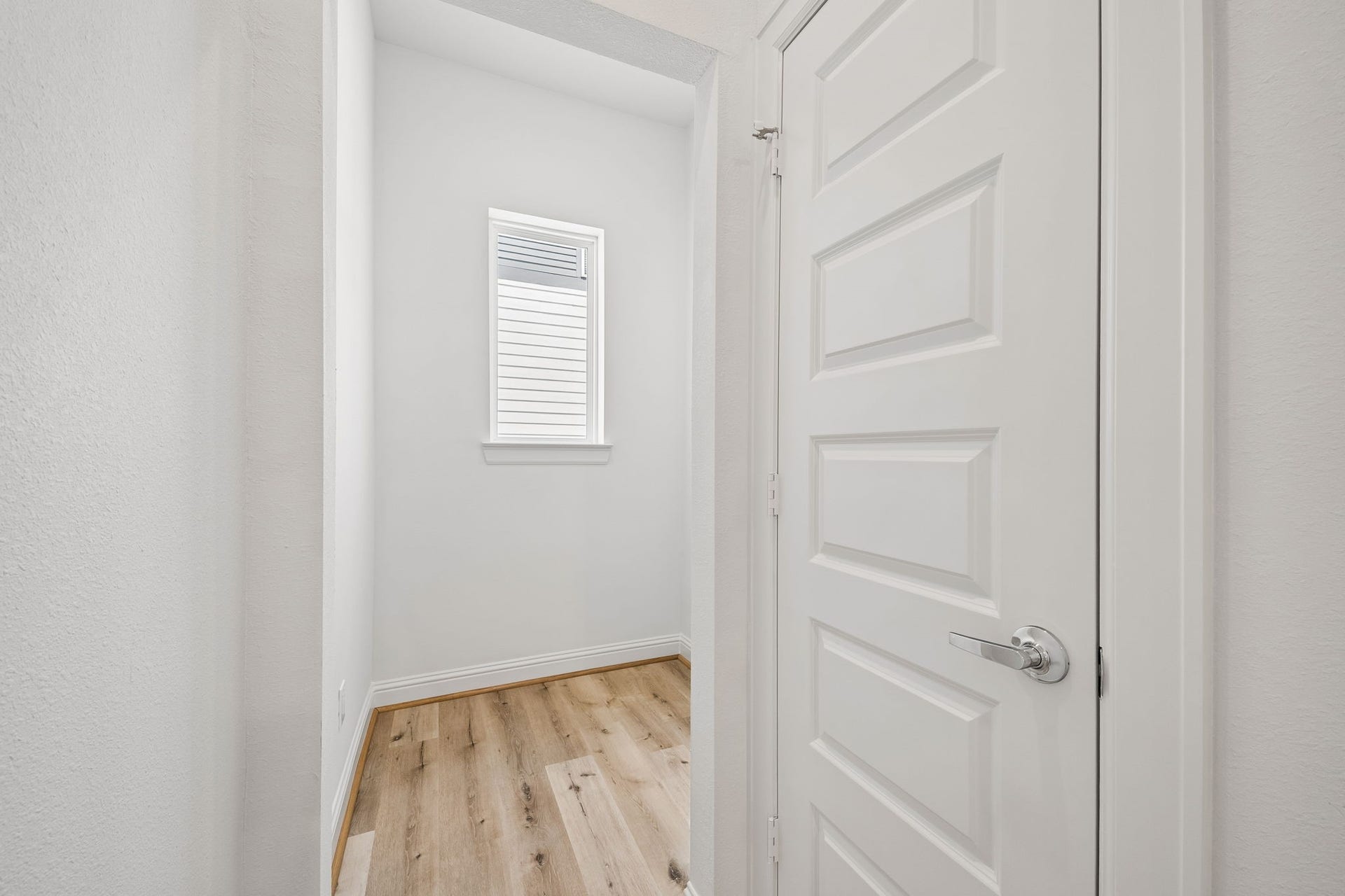 Bright and inviting, this office space features sleek hardwood floors and a window for natural light, providing a perfect setting for productivity.