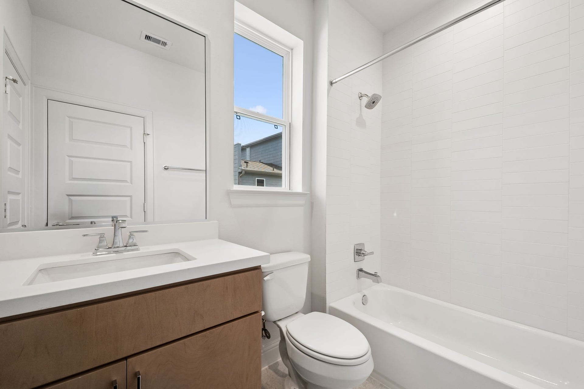 Experience modern elegance in the 3rd-floor bathroom, featuring sleek fixtures, a pristine white bathtub, and abundant natural light for a refreshing ambiance.