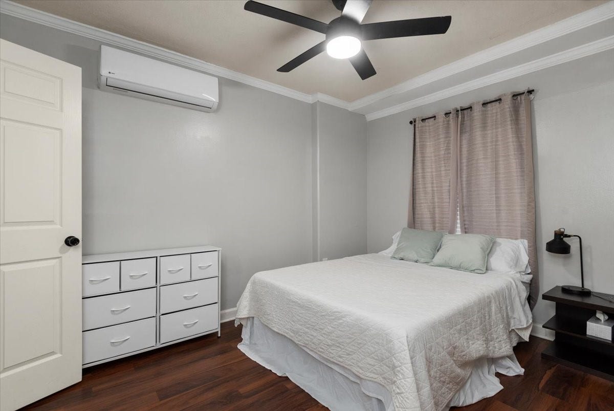 215 Caplin Street, Houston, TX 77022 Spacious bedroom with ceiling fan and natural light.