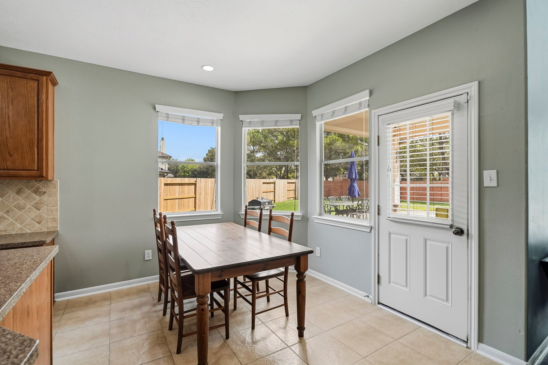 5507 Sandy Trace Court, Katy, TX 77494 The cheerful breakfast area features a beautiful arrangement of windows, tile flooring, and a ceiling fan, creating a bright and comfortable everyday dining space. A nearby exterior door provides convenient access to the covered patio, pool, and backyard.
