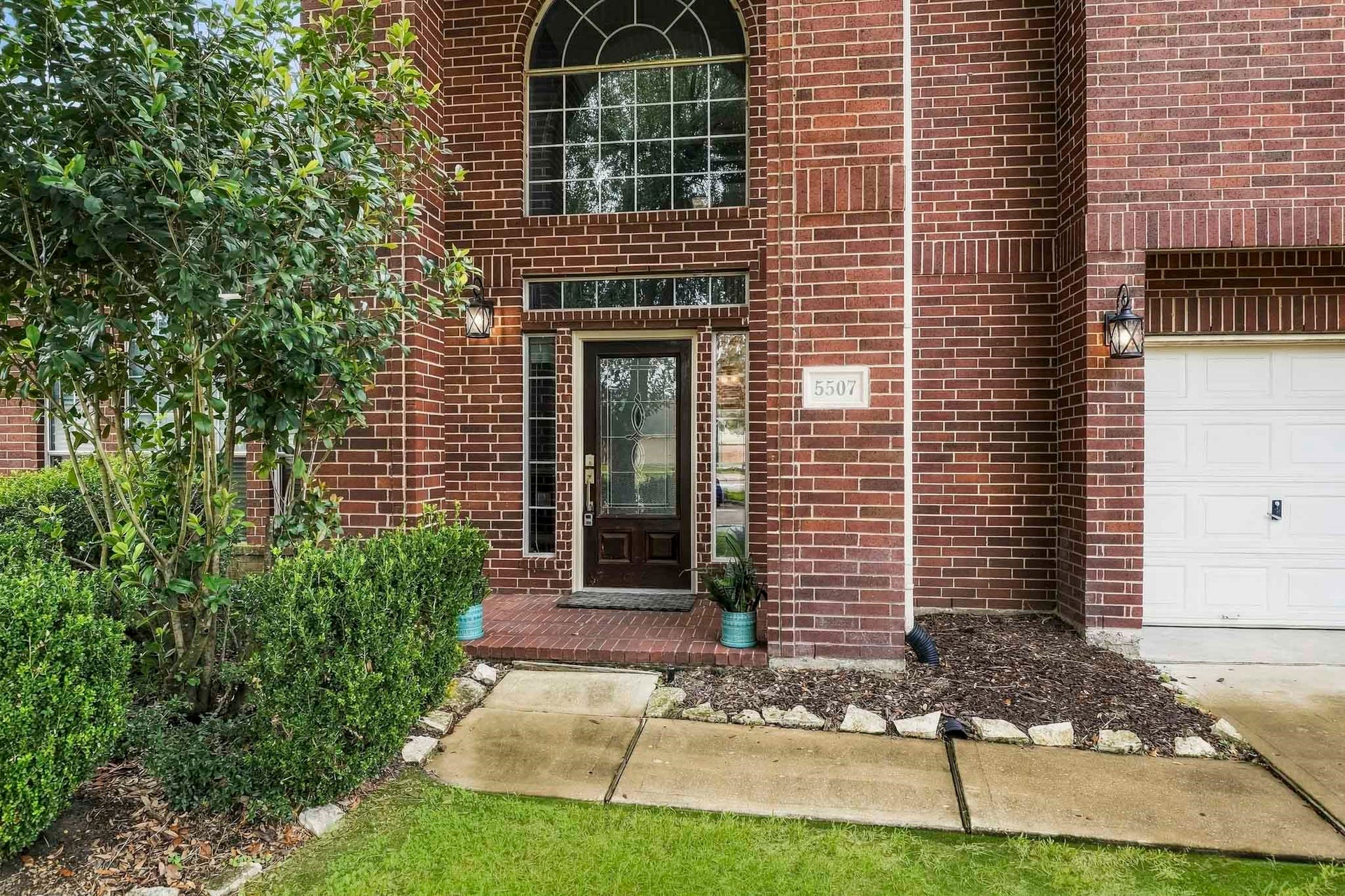 5507 Sandy Trace Court, Katy, TX 77494 A closer look at the home's inviting entrance reveals beautiful brick detailing, an impressive arched window, and a welcoming covered entry.