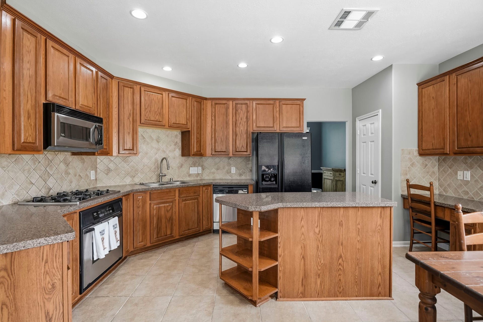 5507 Sandy Trace Court, Katy, TX 77494 The generously sized island kitchen offers an abundance of warm wood cabinetry, expansive countertops, recessed lighting, and a practical layout with plenty of room for meal preparation. A center island provides additional workspace, while the surrounding cabinetry offers excellent storage.