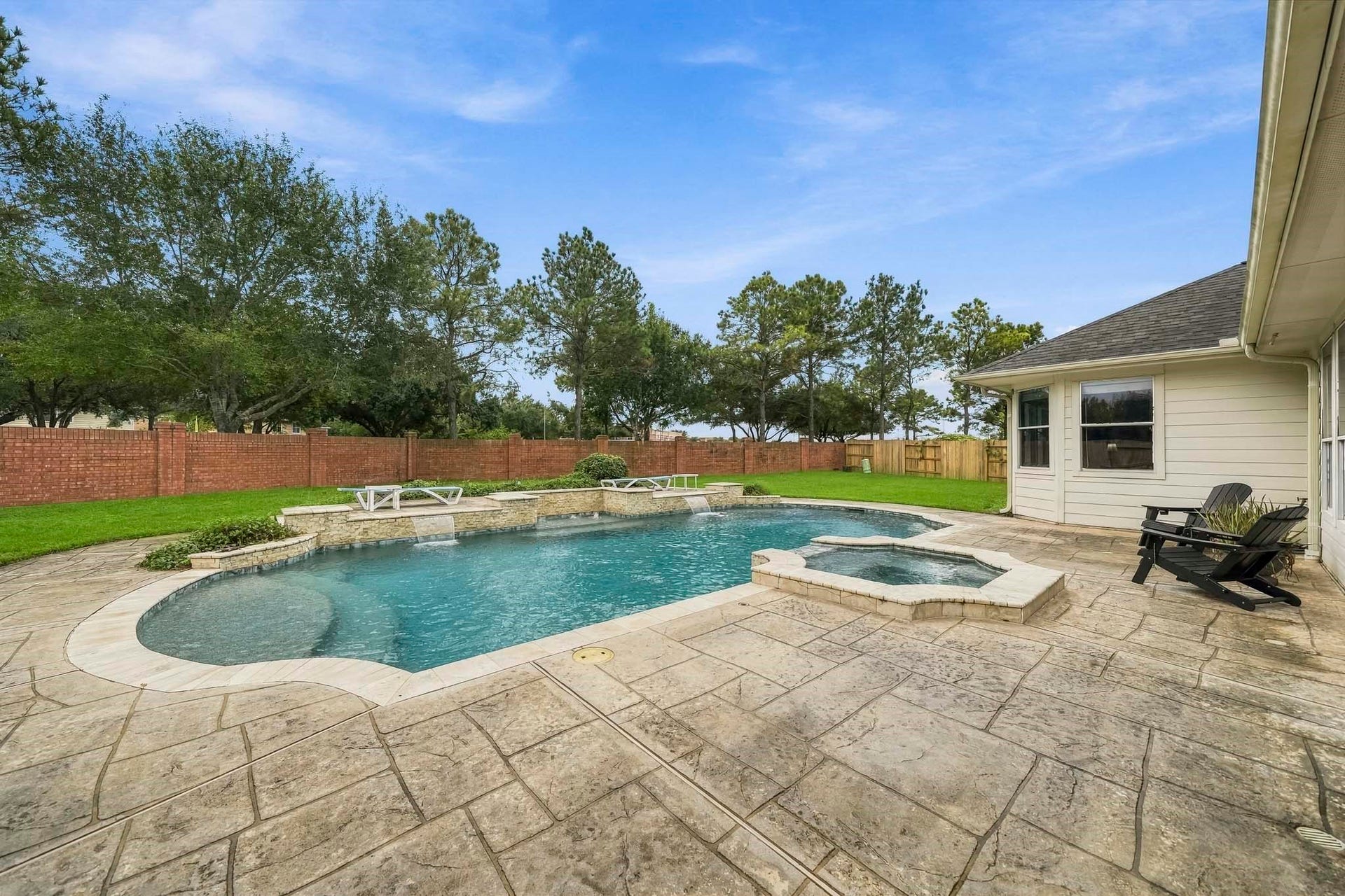 5507 Sandy Trace Court, Katy, TX 77494 This expansive view captures the wonderful scale of the backyard retreat, featuring a sparkling pool, attached spa, generous patio decking, and an impressive stretch of green lawn. The absence of rear neighbors adds to the open setting, creating an exceptional space for outdoor entertaining and recreation.