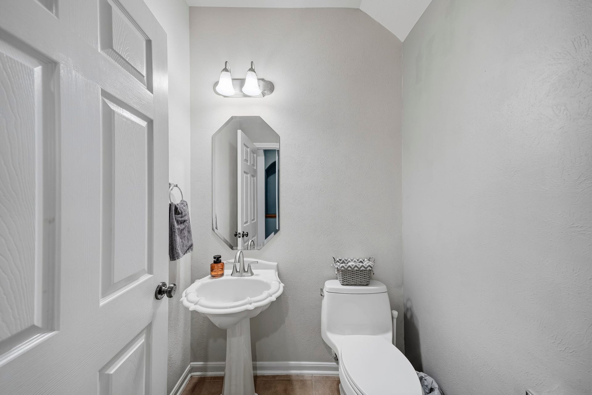 5507 Sandy Trace Court, Katy, TX 77494 Conveniently located on the first floor, the guest powder room features a pedestal sink, decorative mirror, and classic fixtures. Its neutral finishes and accessible location make it a practical addition for visitors and everyday use.