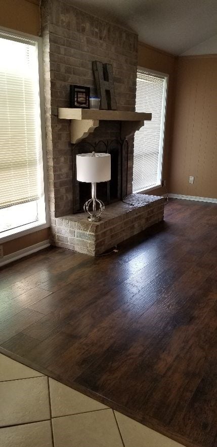 Wood floors and fireplace in den