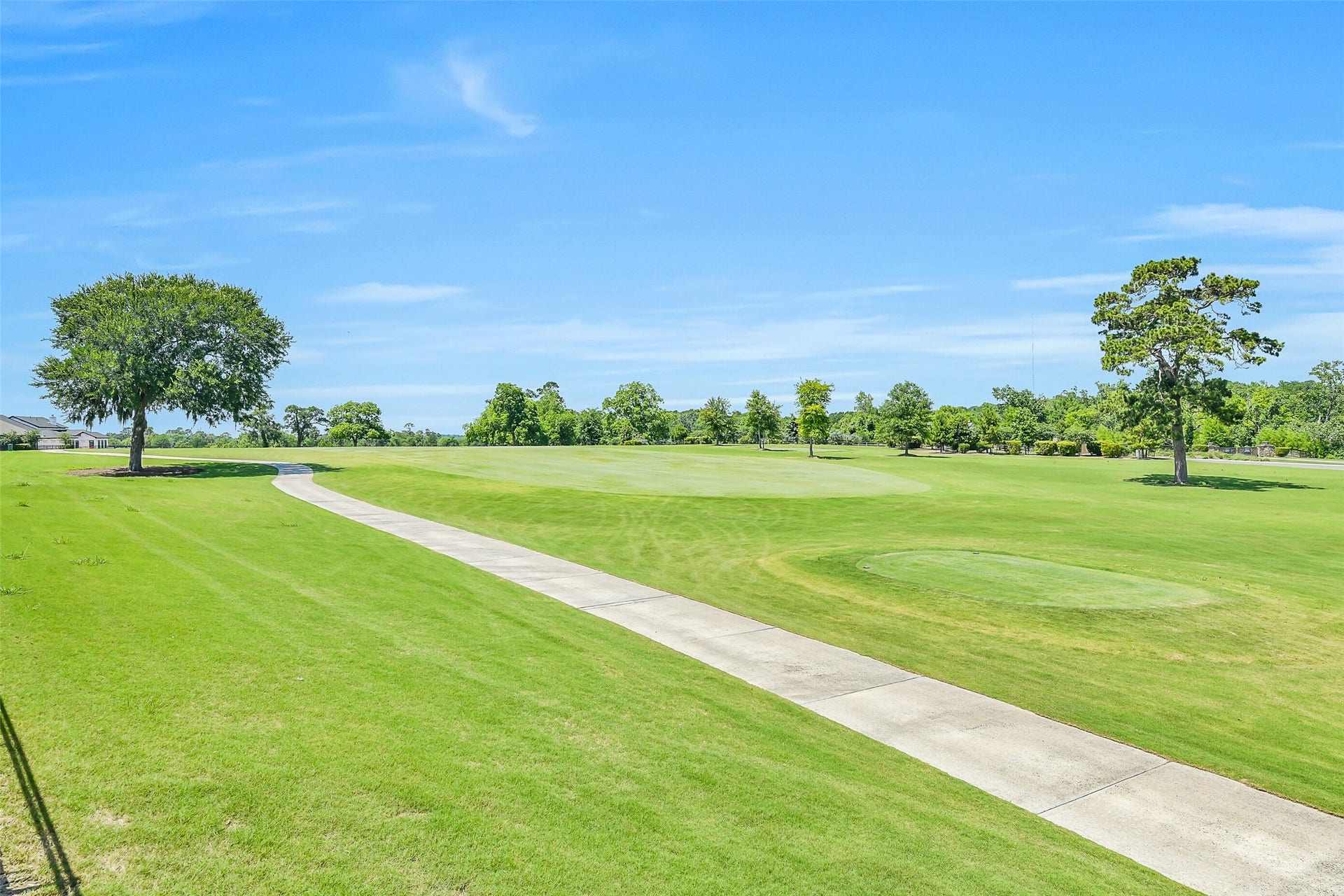 Cart path behind the home. The neighborhood features a 9-hole course featuring large greens, flat bunkers, and varied, natural terrain.