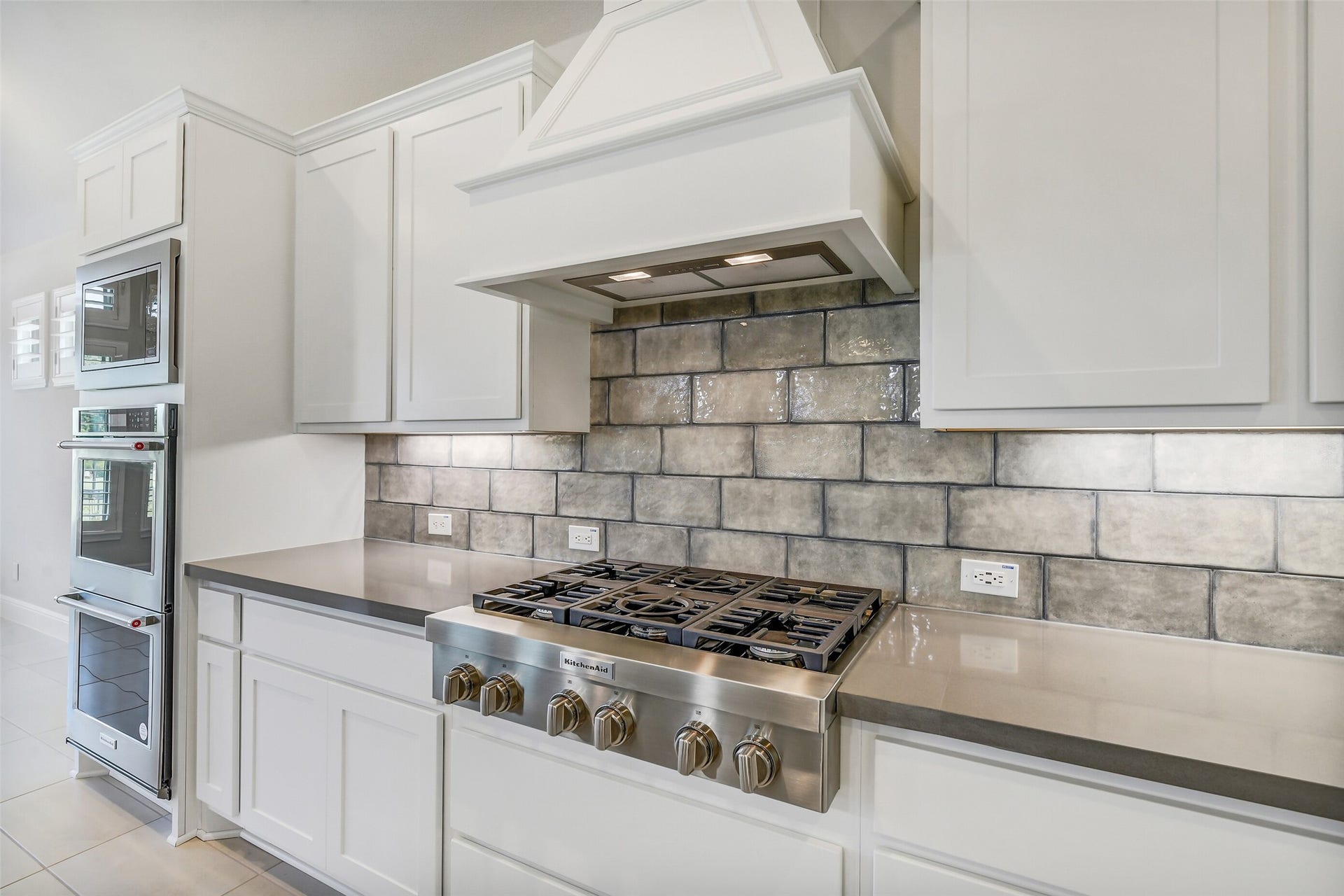 The six burner Kitchenaid cook top can handle big and small meals.  The tile flooring and backsplash makes for easy clean up.