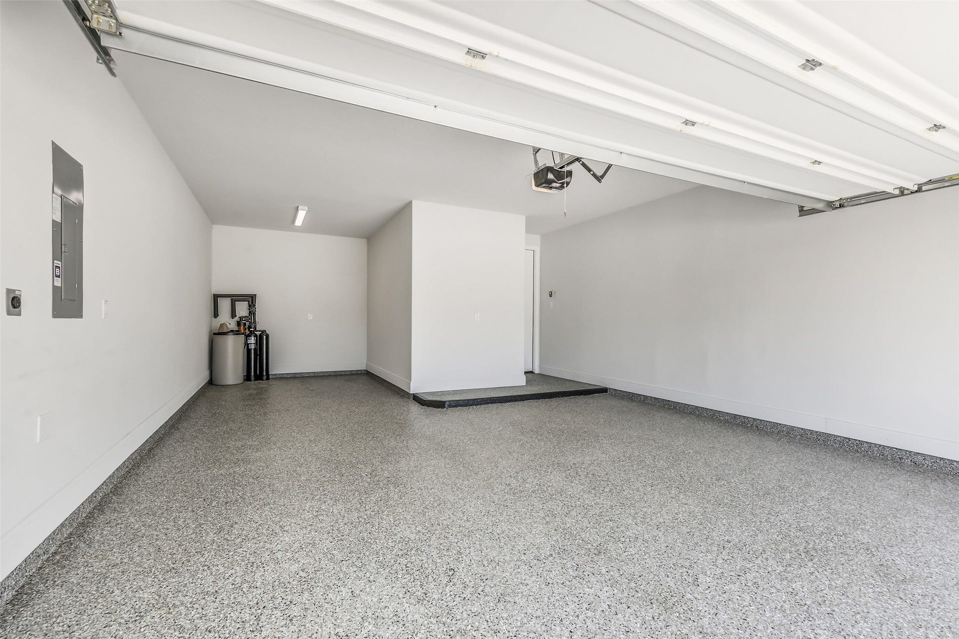 The garage has epoxy flooring plus has space for golf cart storage.  The garage door has overhead opener.  A water softener system has been installed in the garage.