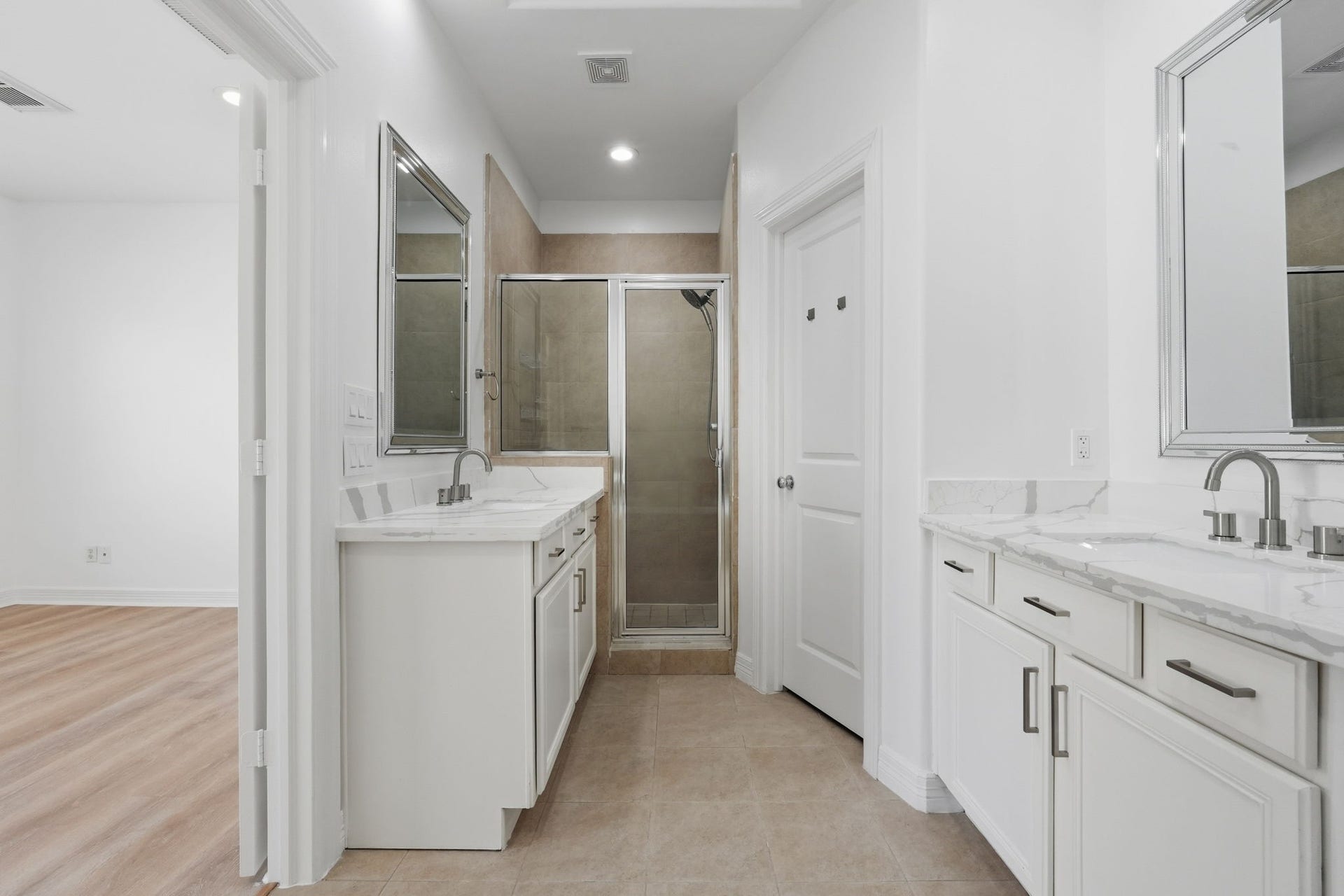 3882 Center Street, Houston, TX 77007 The primary bathroom highlights its functional layout, with separate vanity areas, generous cabinet storage, and a central walkway that allows for easy movement throughout the space. (3rd floor)