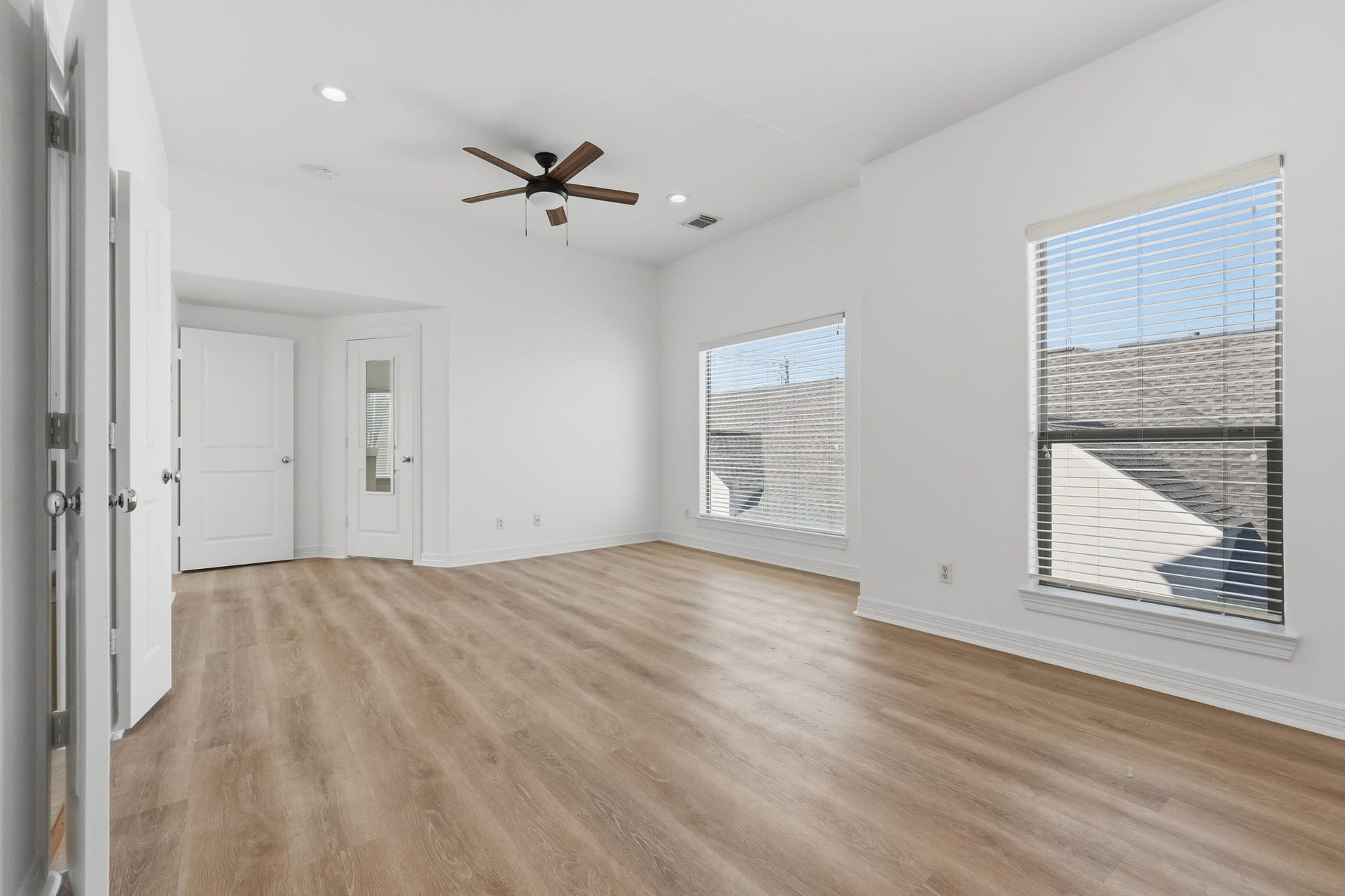 3882 Center Street, Houston, TX 77007 Another view of the primary bedroom highlights its expansive layout and multiple windows, complemented by a ceiling fan and neutral finishes for a bright, open feel. (3rd floor)