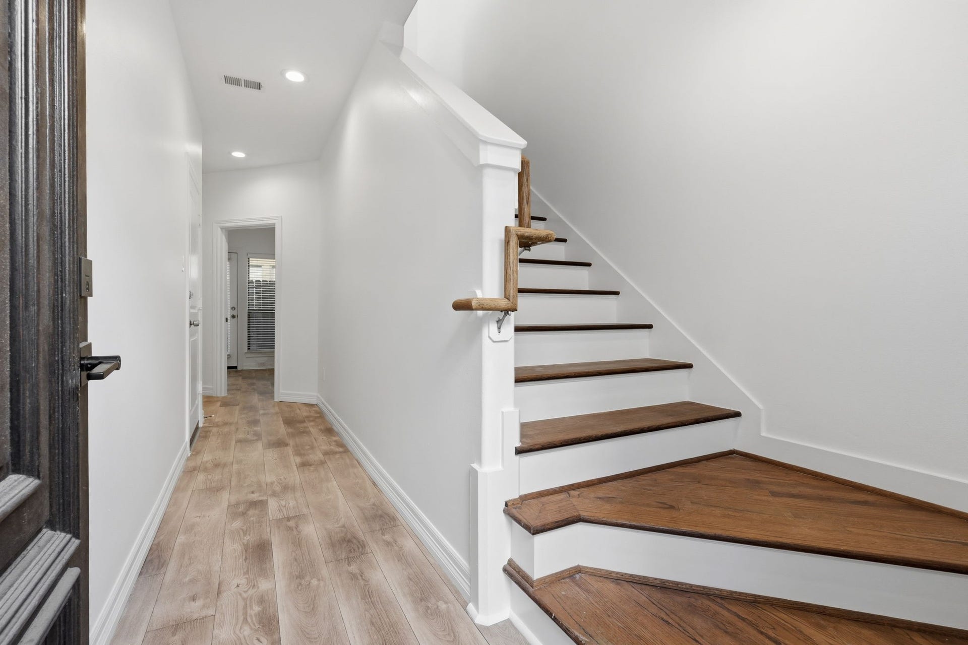 3882 Center Street, Houston, TX 77007 A welcoming entryway leads to a staircase with wood treads and crisp white risers, complemented by light-toned flooring and clean finishes for a polished first impression.