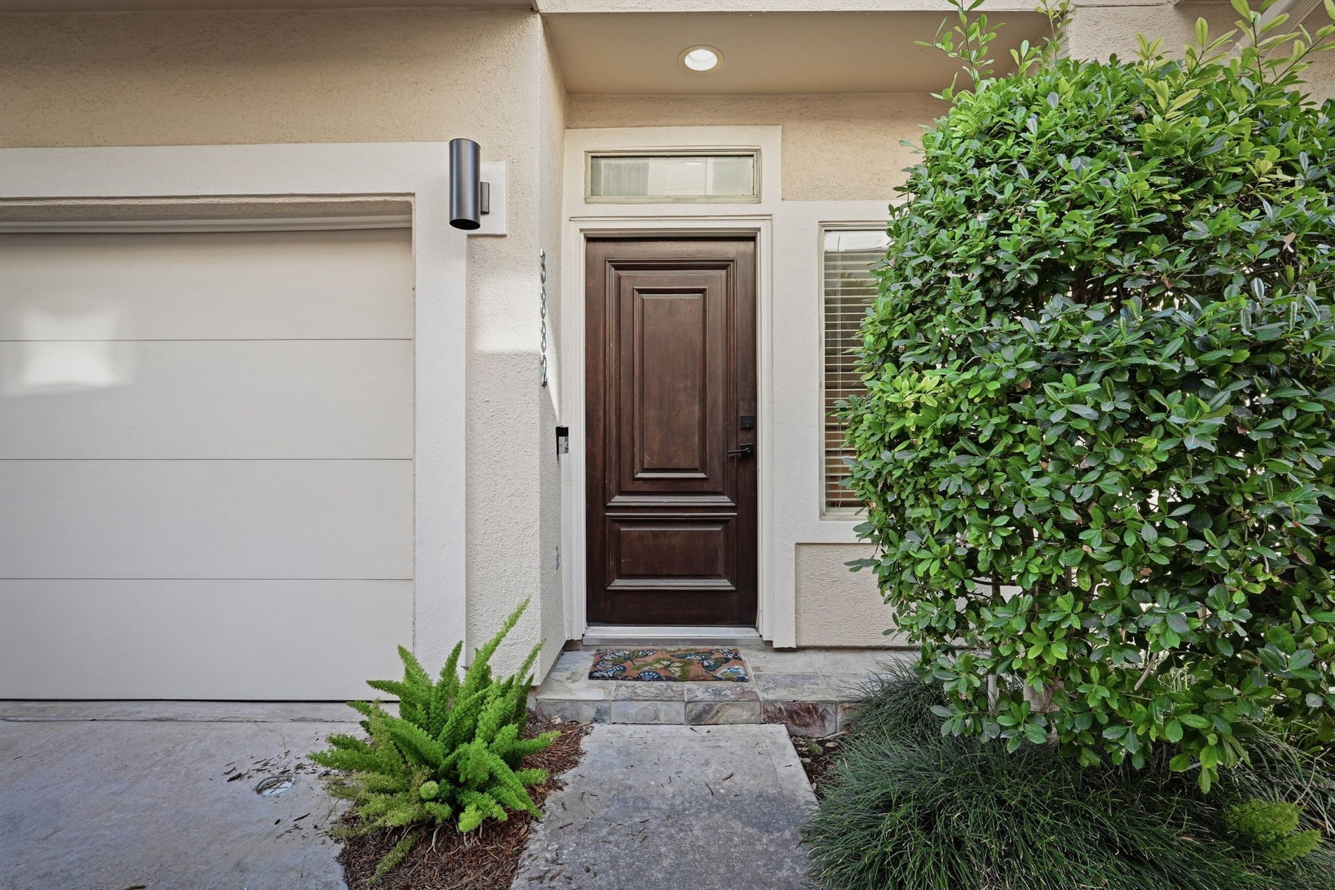 3882 Center Street, Houston, TX 77007 Welcoming front entry featuring a rich wood-paneled door, transom window, tiled porch, and manicured landscaping.