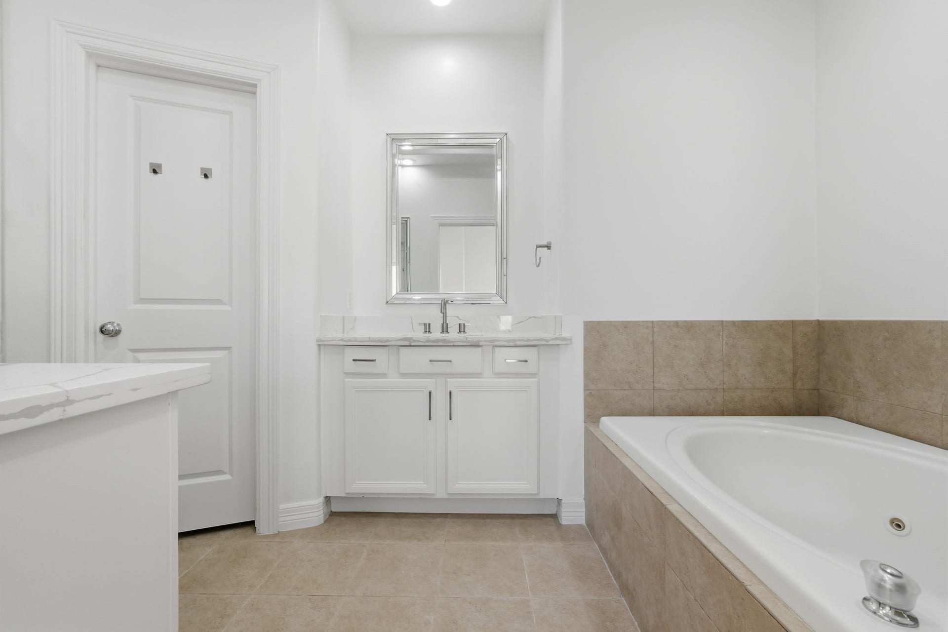 3882 Center Street, Houston, TX 77007 Another view of the primary bathroom features a jetted tub with a tiled surround, and a spacious vanity with generous counter space, combining refined finishes with added comfort and convenience. (3rd floor)