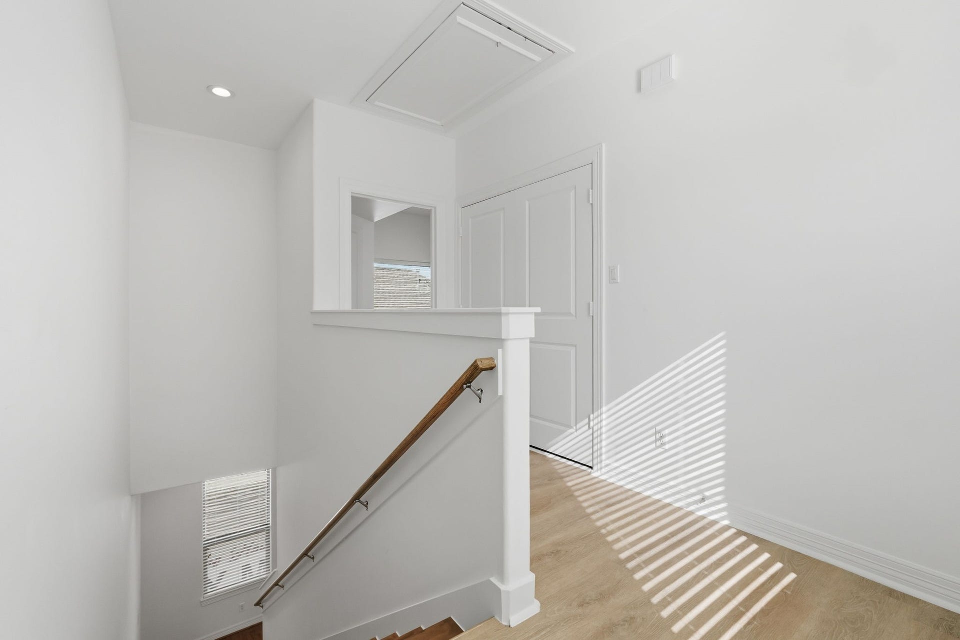 3882 Center Street, Houston, TX 77007 The upstairs landing features a clean, neutral design with white walls, a simple railing, and natural light filtering through nearby windows, creating a bright and welcoming transition between the upper-level rooms. (3rd floor)