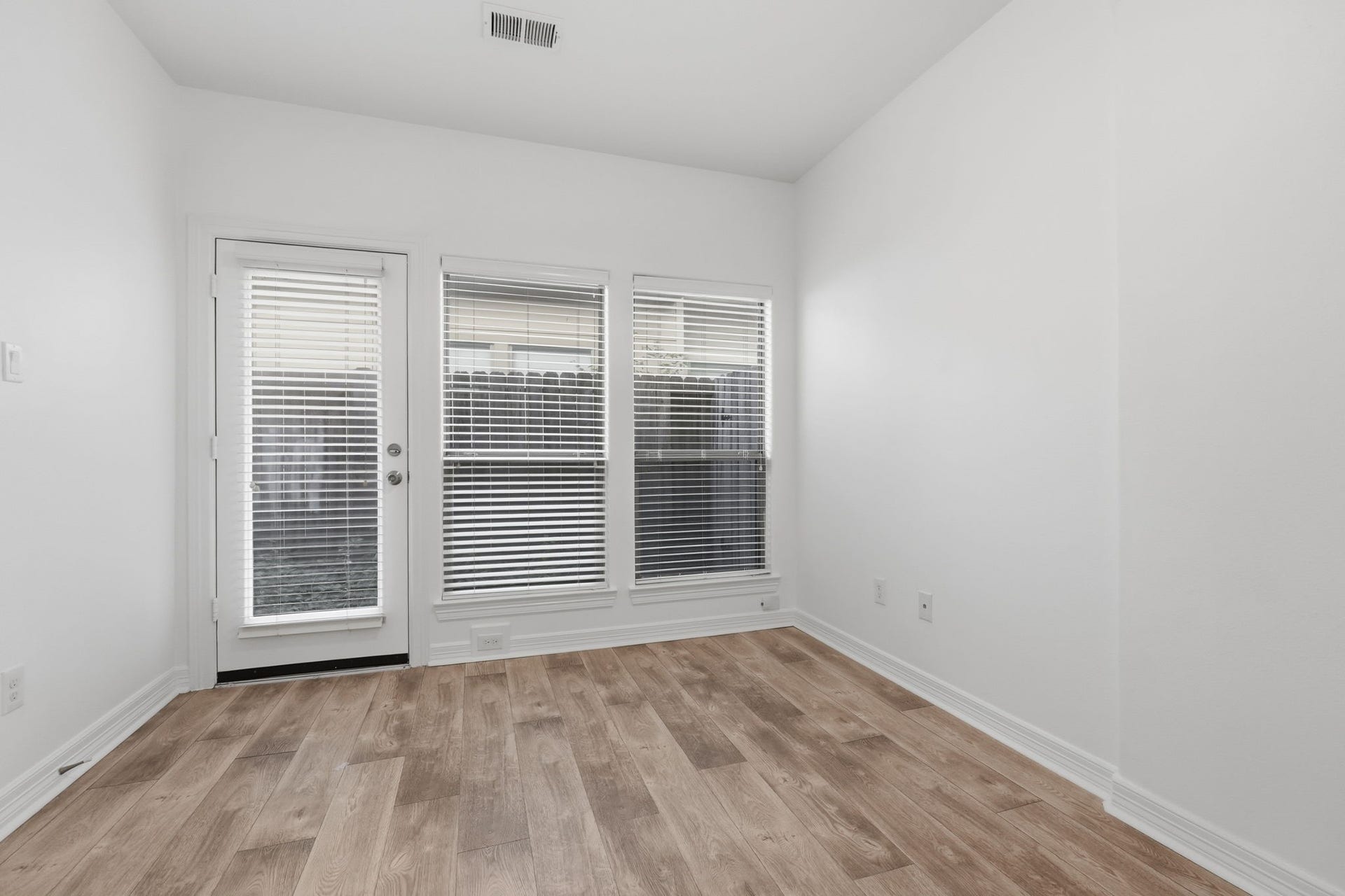 3882 Center Street, Houston, TX 77007 The secondary bedroom #1 features a clean, neutral palette, recessed lighting, and a wide set of windows that bring in natural light, offering a versatile space. (1st floor)
