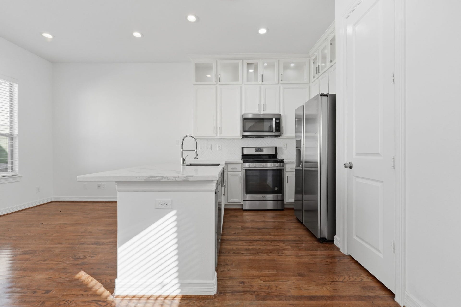 3882 Center Street, Houston, TX 77007 The kitchens clean-lined cabinetry, stainless steel appliances, and extended breakfast bar create a functional workspace, while the open layout provides an easy transition into the dining and main living area.