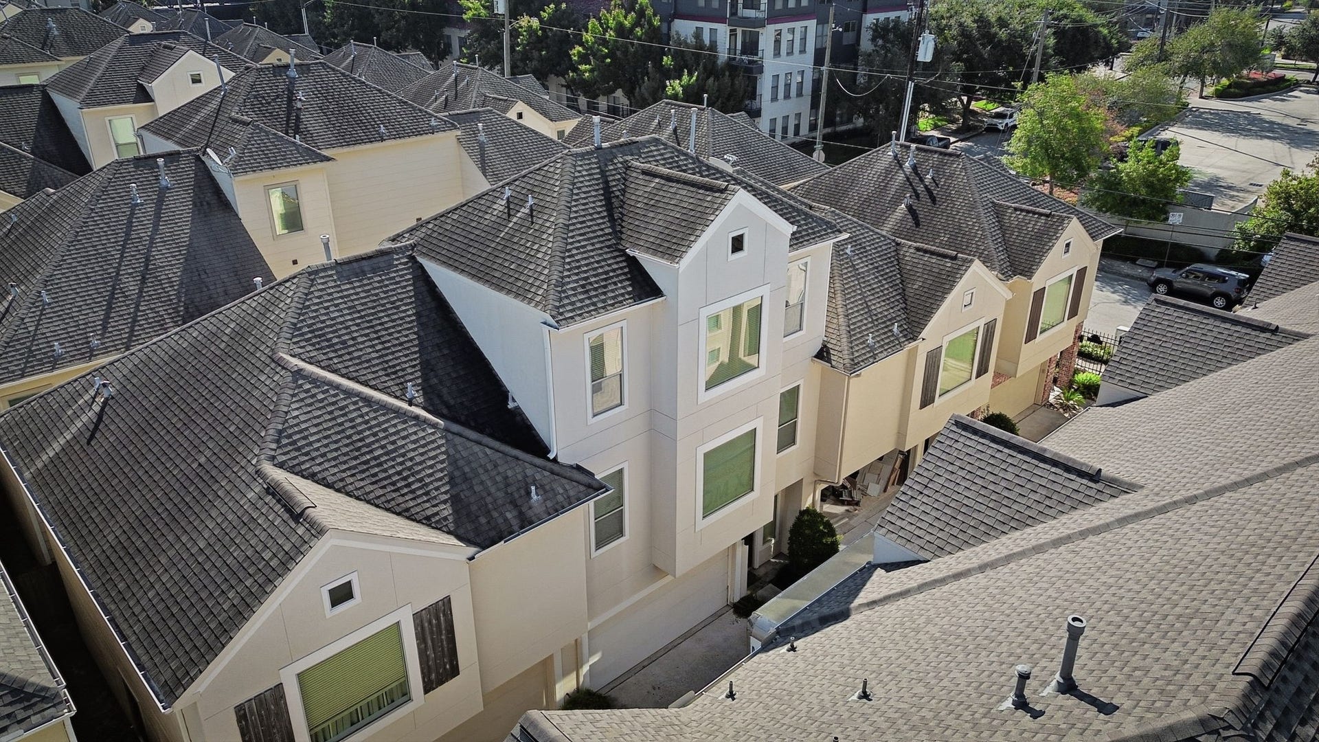 3882 Center Street, Houston, TX 77007 An aerial view showcases the homes multi-story exterior, featuring a distinctive roofline, neutral siding, and a cohesive architectural style within a well-established residential community.