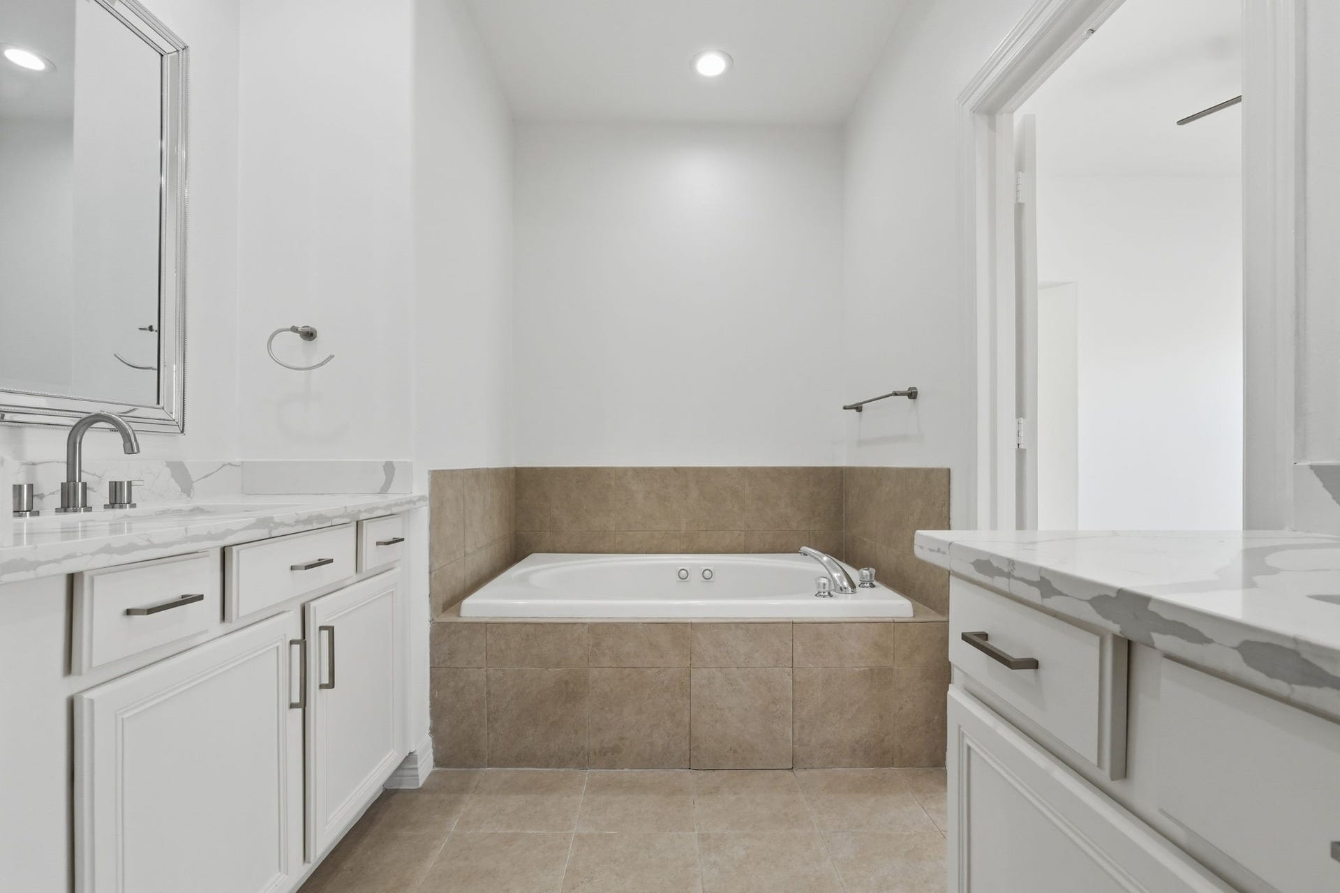 3882 Center Street, Houston, TX 77007 The primary bathrooms jetted tub takes center stage, featuring a tiled surround and positioned between the dual vanities for a well-appointed and functional layout.
