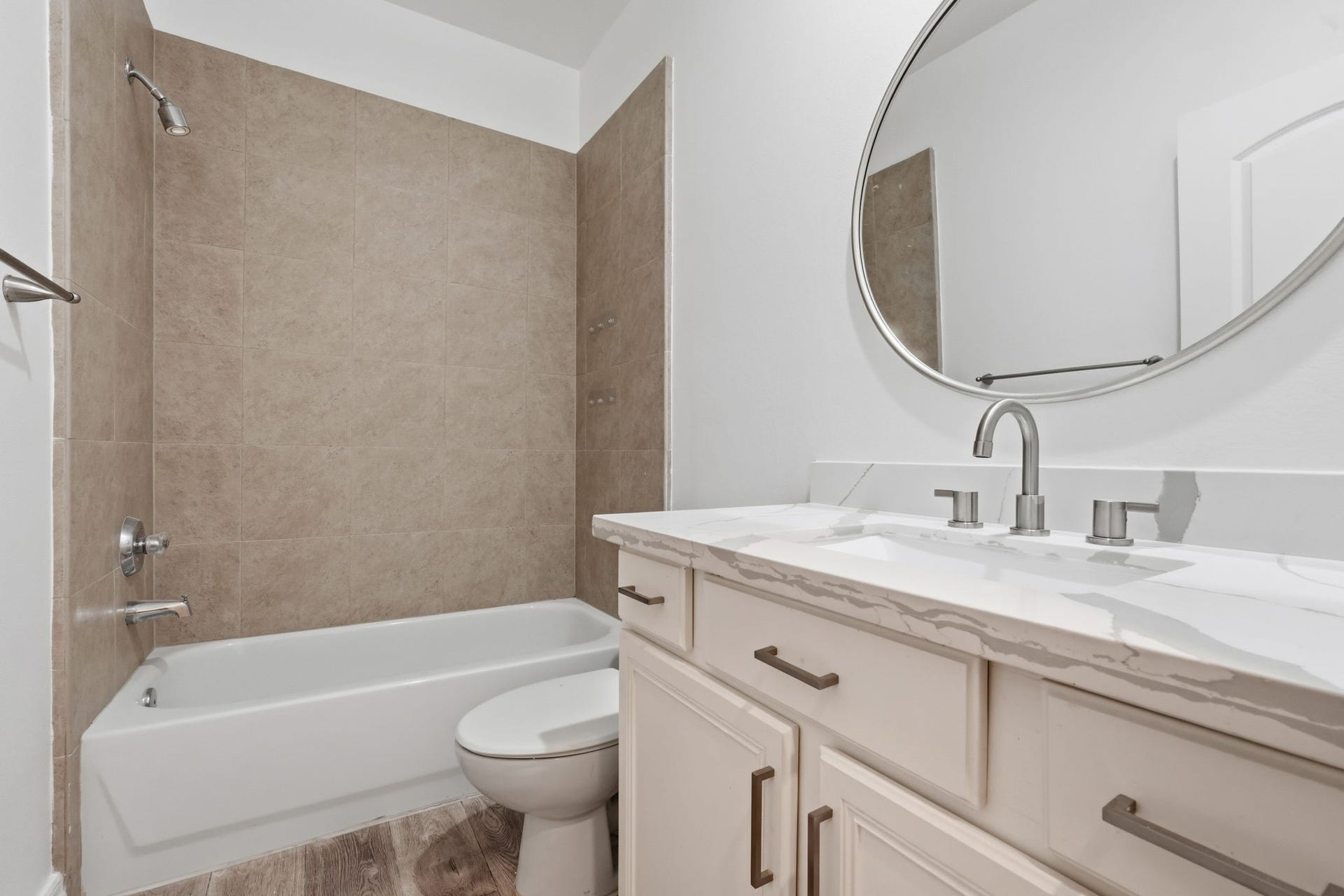 3882 Center Street, Houston, TX 77007 The secondary bathroom features a tub and shower combination with neutral tile surrounds, a spacious vanity, and a large mirror, blending clean finishes with everyday functionality. (1st floor)