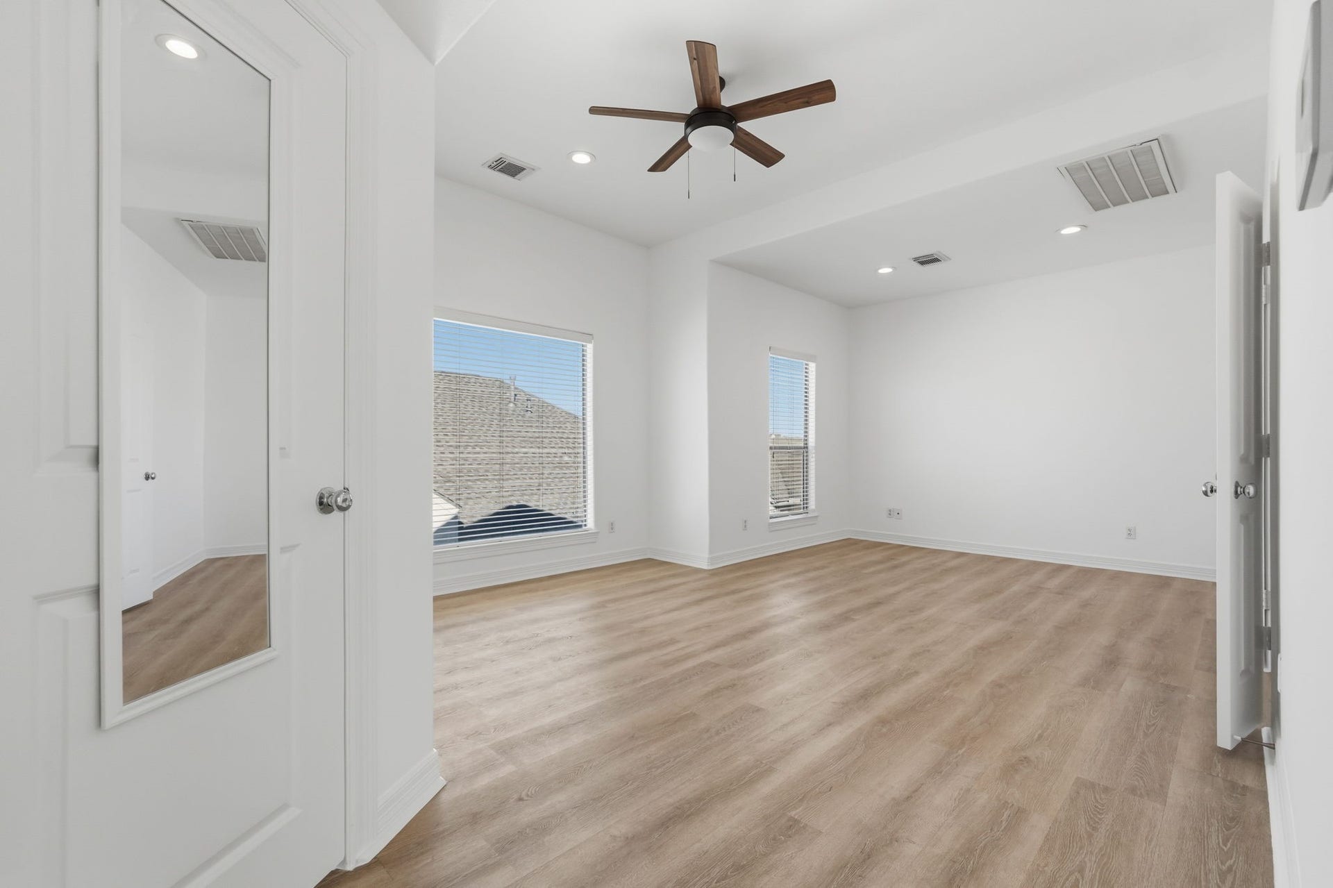 3882 Center Street, Houston, TX 77007 The primary bedroom features a spacious layout, vaulted ceilings, a ceiling fan, and large windows that invite natural light, creating a bright and airy retreat with a clean, modern feel. (3rd floor)
