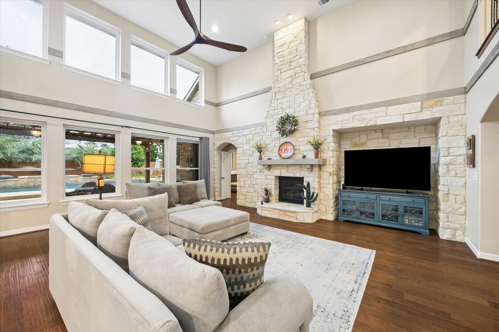 24935 Waterstone Estates Circle W, Tomball, TX 77375 Expansive windows fill the family room with natural light while offering beautiful views of the backyard and resort-style pool. Soaring ceilings and the impressive floor-to-ceiling stone fireplace create a warm and inviting space to relax and enjoy the homes exceptional indoor-outdoor setting.