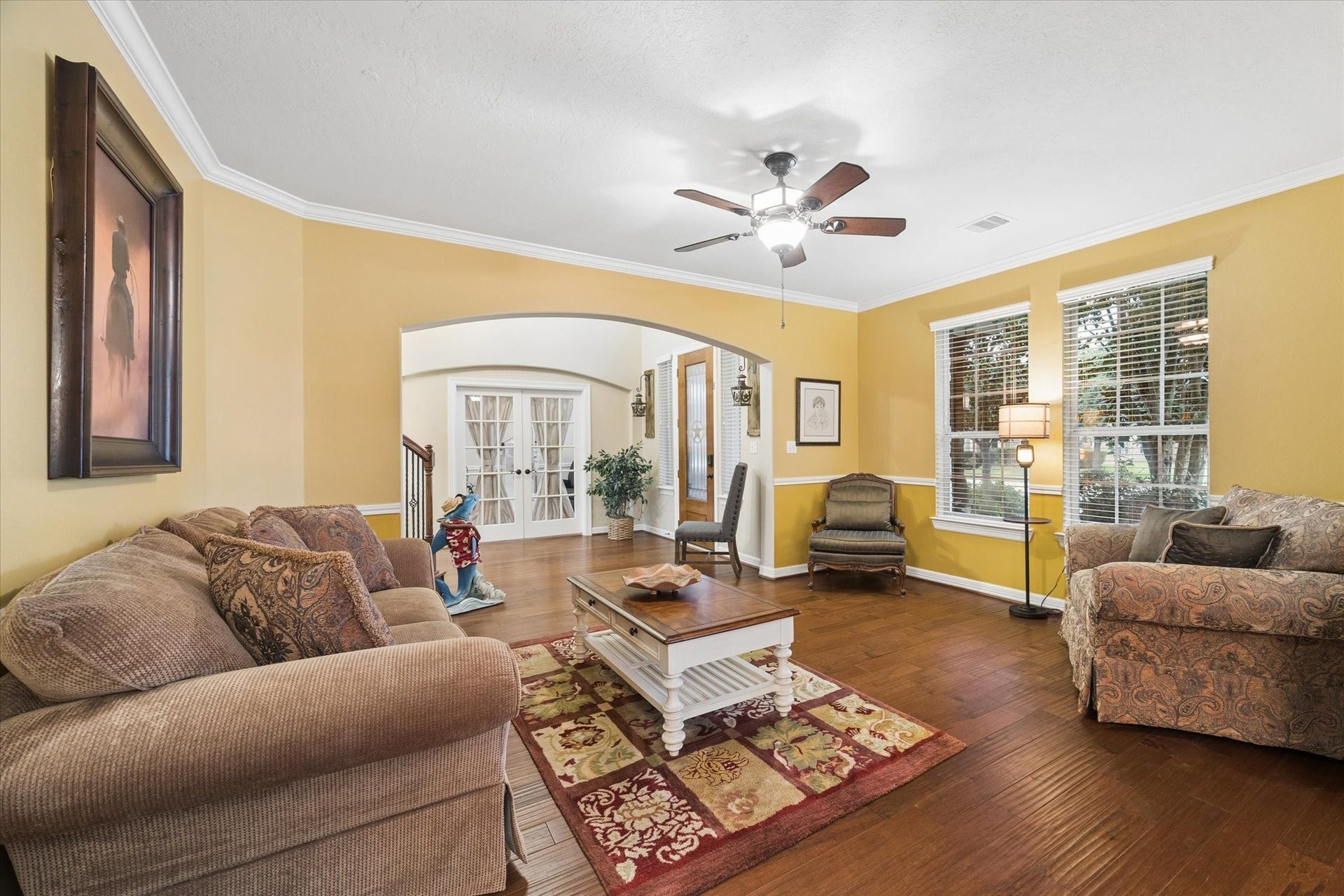 24935 Waterstone Estates Circle W, Tomball, TX 77375 Another perspective of the spacious living room highlights its warm and inviting atmosphere, with rich hardwood floors, crown molding, and abundant natural light. The generous layout offers plenty of space to relax, gather, and enjoy everyday living.