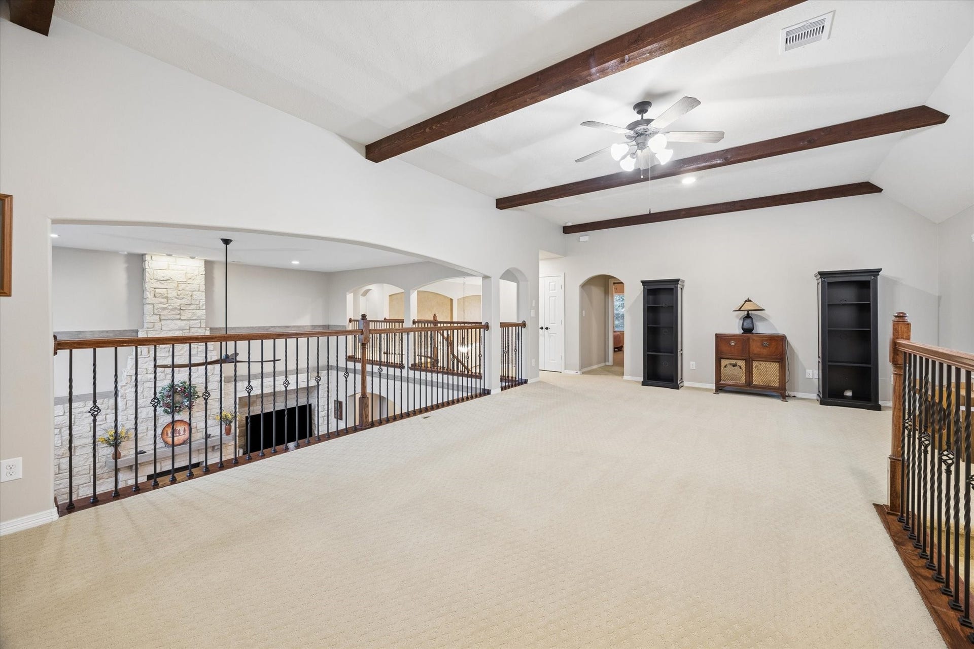 24935 Waterstone Estates Circle W, Tomball, TX 77375 The expansive second-floor game room offers a versatile space for entertaining and relaxation, highlighted by vaulted ceilings with exposed wood beams and an open overlook to the family room below. Its generous proportions provide endless possibilities for a media area, billiards, or additional gathering space.