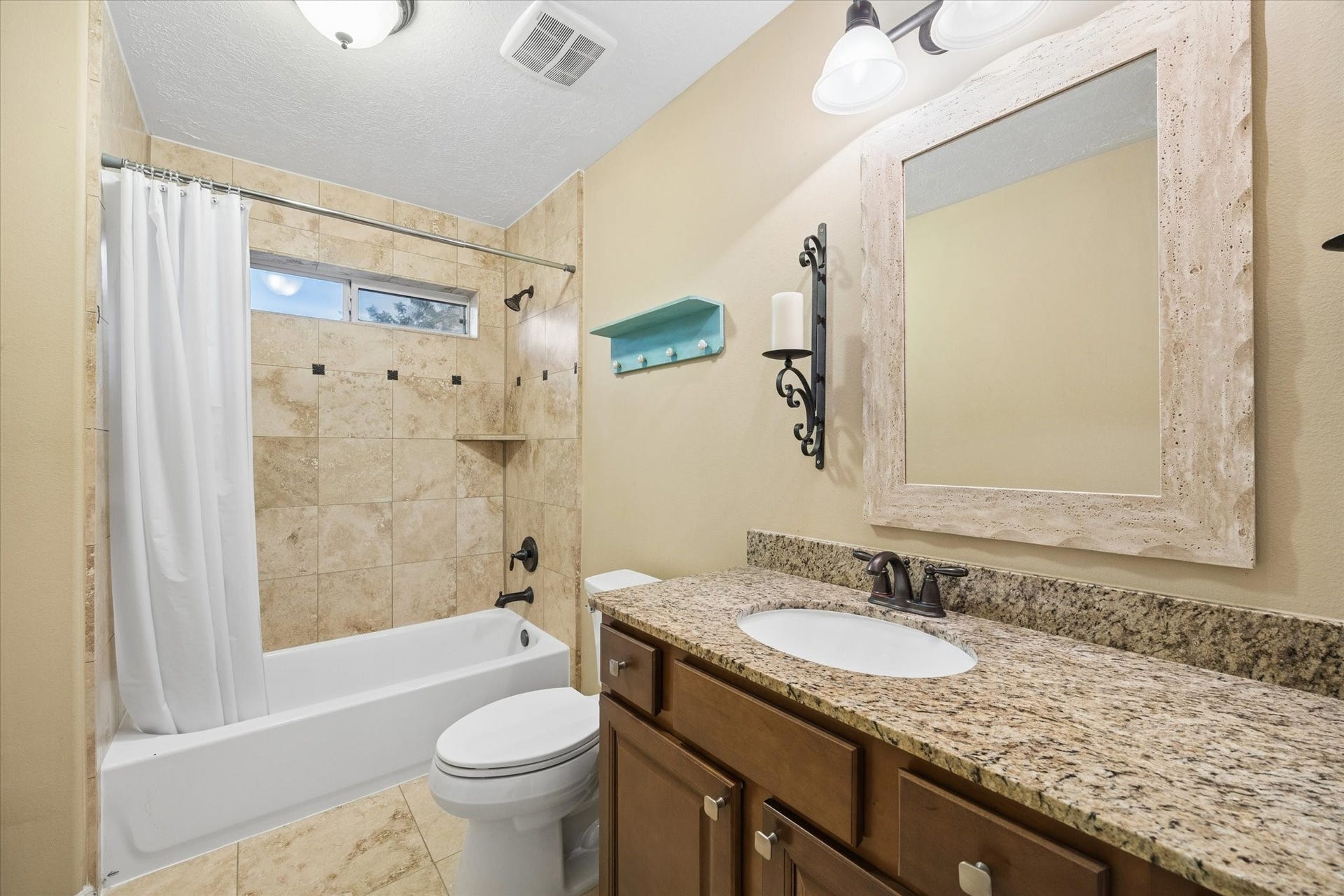 24935 Waterstone Estates Circle W, Tomball, TX 77375 Well-appointed upstairs secondary bathroom featuring a granite-topped vanity and a beautifully tiled tub and shower combination.