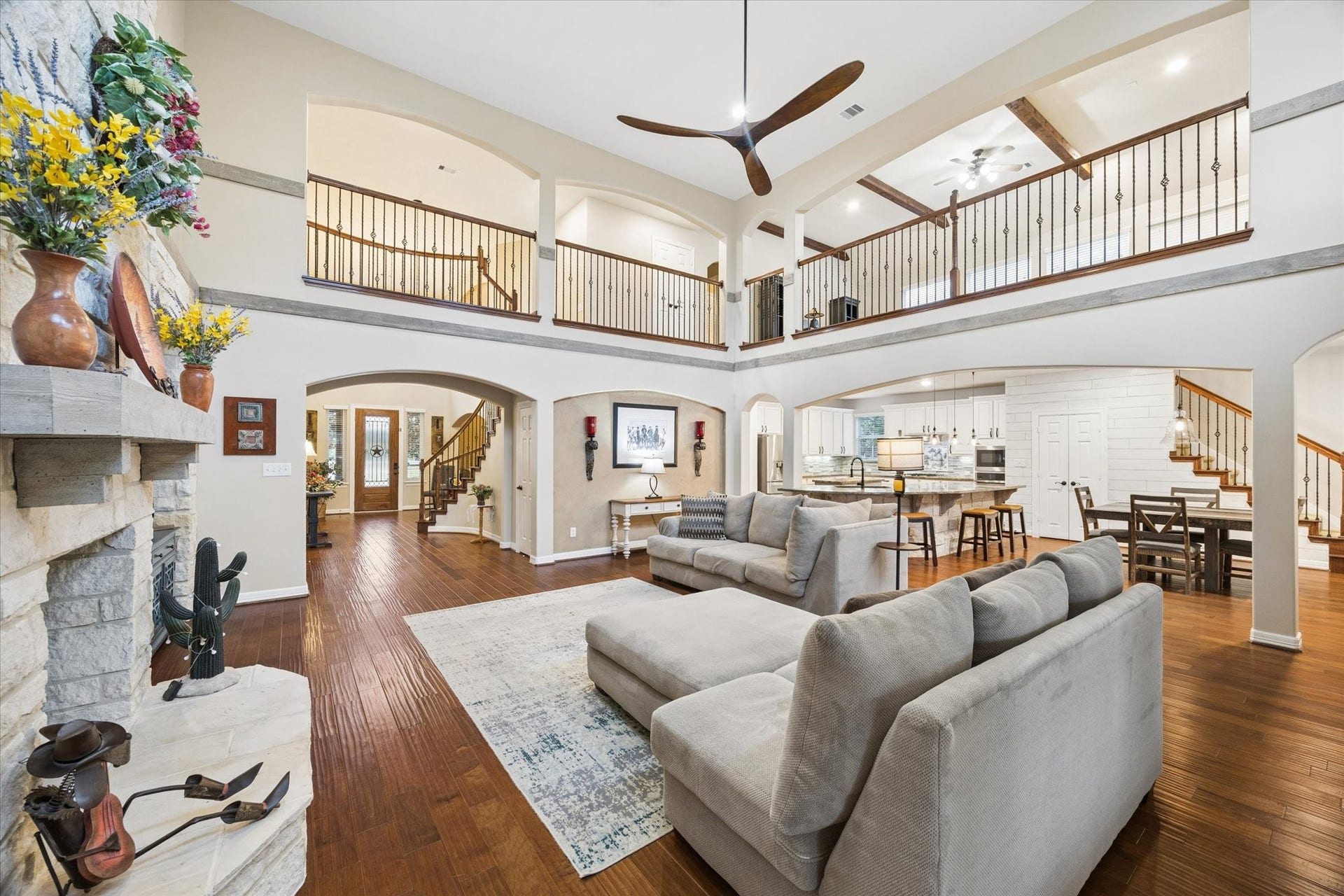 24935 Waterstone Estates Circle W, Tomball, TX 77375 The impressive family room serves as the heart of the home, featuring soaring ceilings, rich hardwood floors, striking wood accents, and a beautiful stone fireplace. The open-concept design offers views of the second-level gallery and flows seamlessly into the kitchen and breakfast area, creating an exceptional setting for everyday living and entertaining.