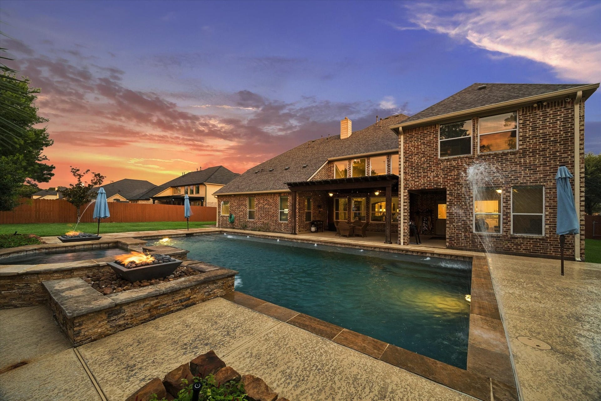 24935 Waterstone Estates Circle W, Tomball, TX 77375 Enjoy unforgettable evenings in this beautifully designed outdoor oasis, featuring an impressive pool, dramatic fire and water elements, and a covered patio ideal for year-round outdoor livingall framed by a stunning Texas sunset.