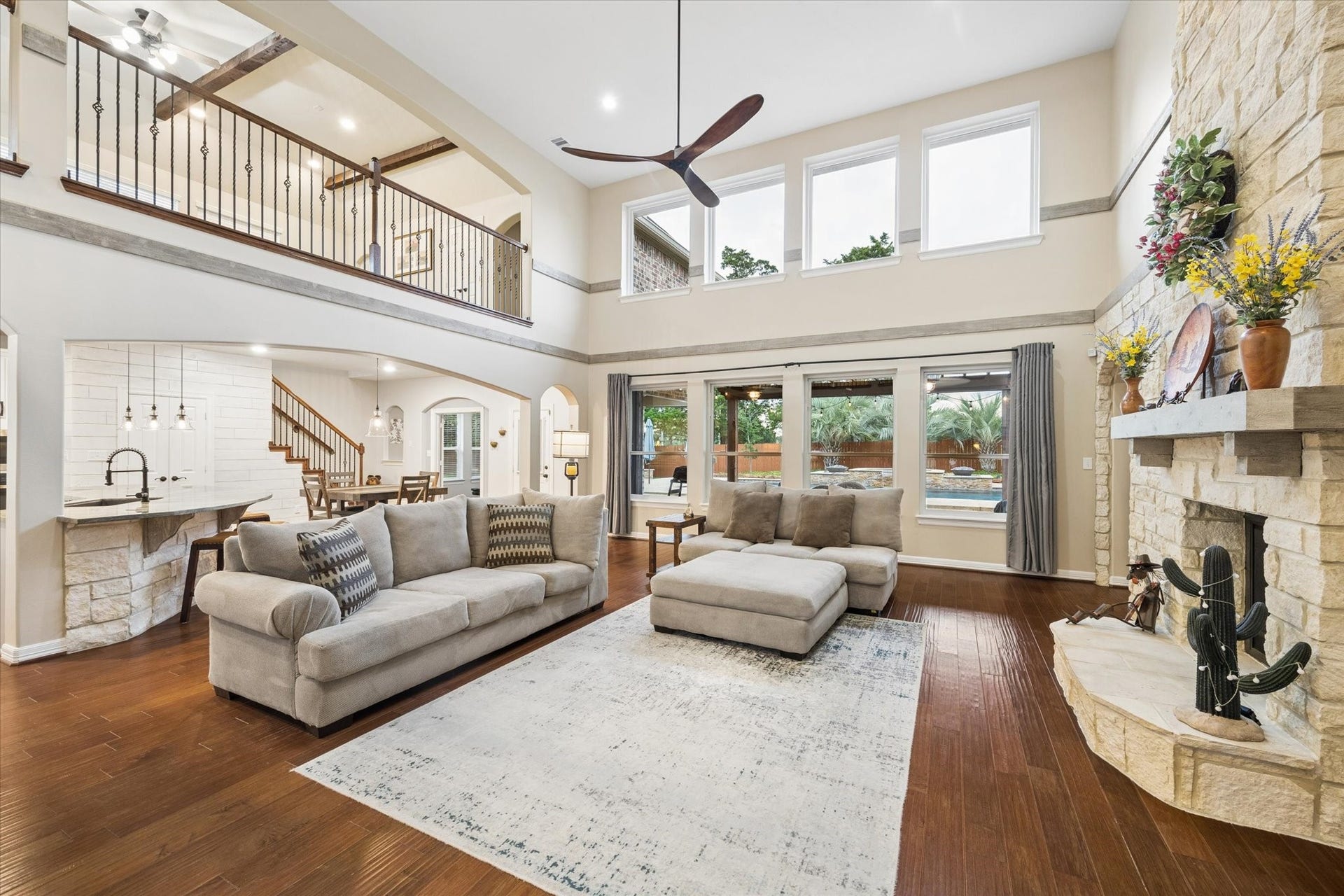 24935 Waterstone Estates Circle W, Tomball, TX 77375 Simply exquisite. Bathed in natural light, this impressive family room showcases soaring ceilings, rich hardwood floors, and a dramatic stone fireplace. Expansive windows frame beautiful views of the pool and outdoor living spaces, while the open-concept design creates a seamless connection to the kitchen and breakfast areaan exceptional setting for both everyday living and entertaining.