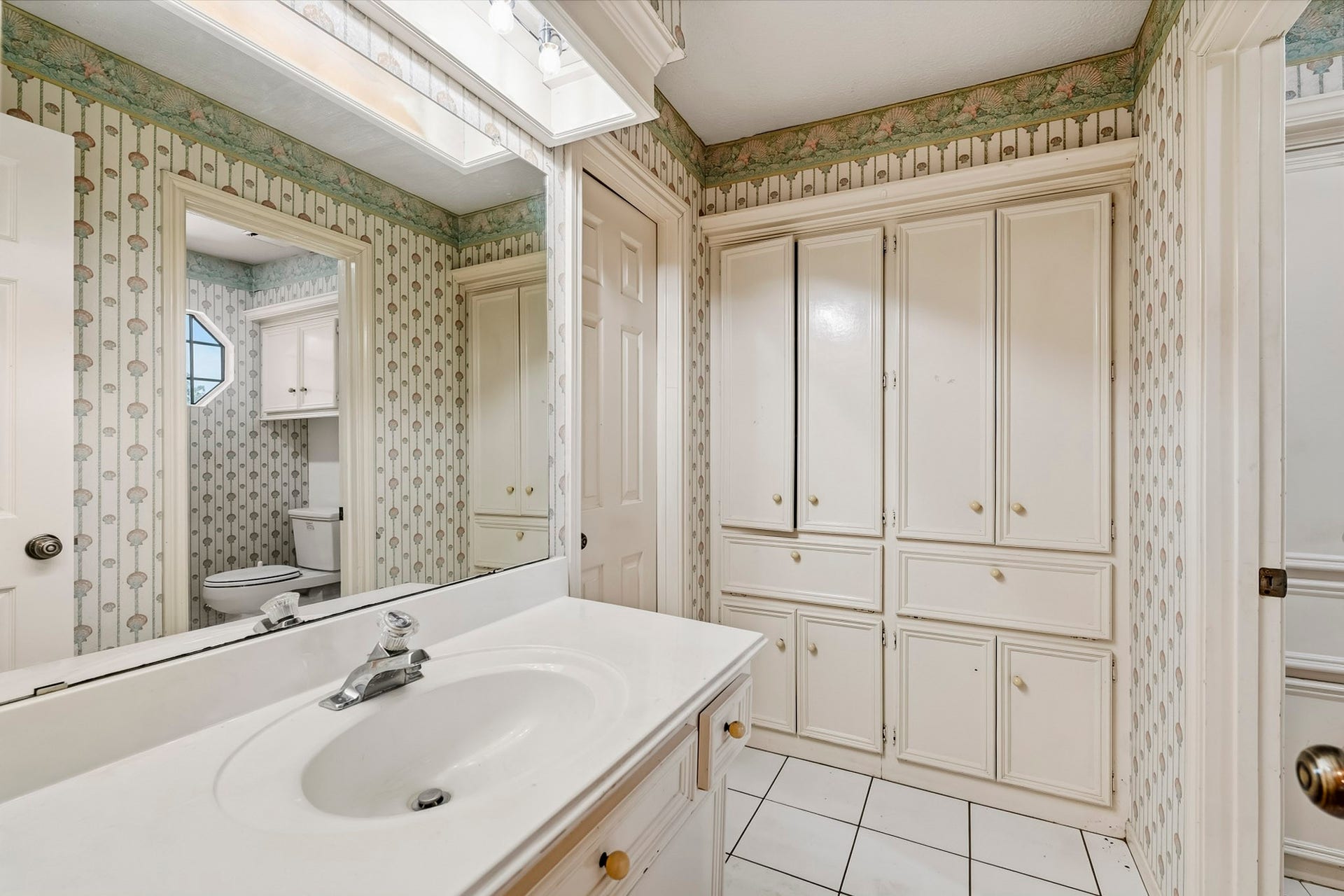 Full secondary bath designed for convenience with extensive built-in storage cabinets and drawers.