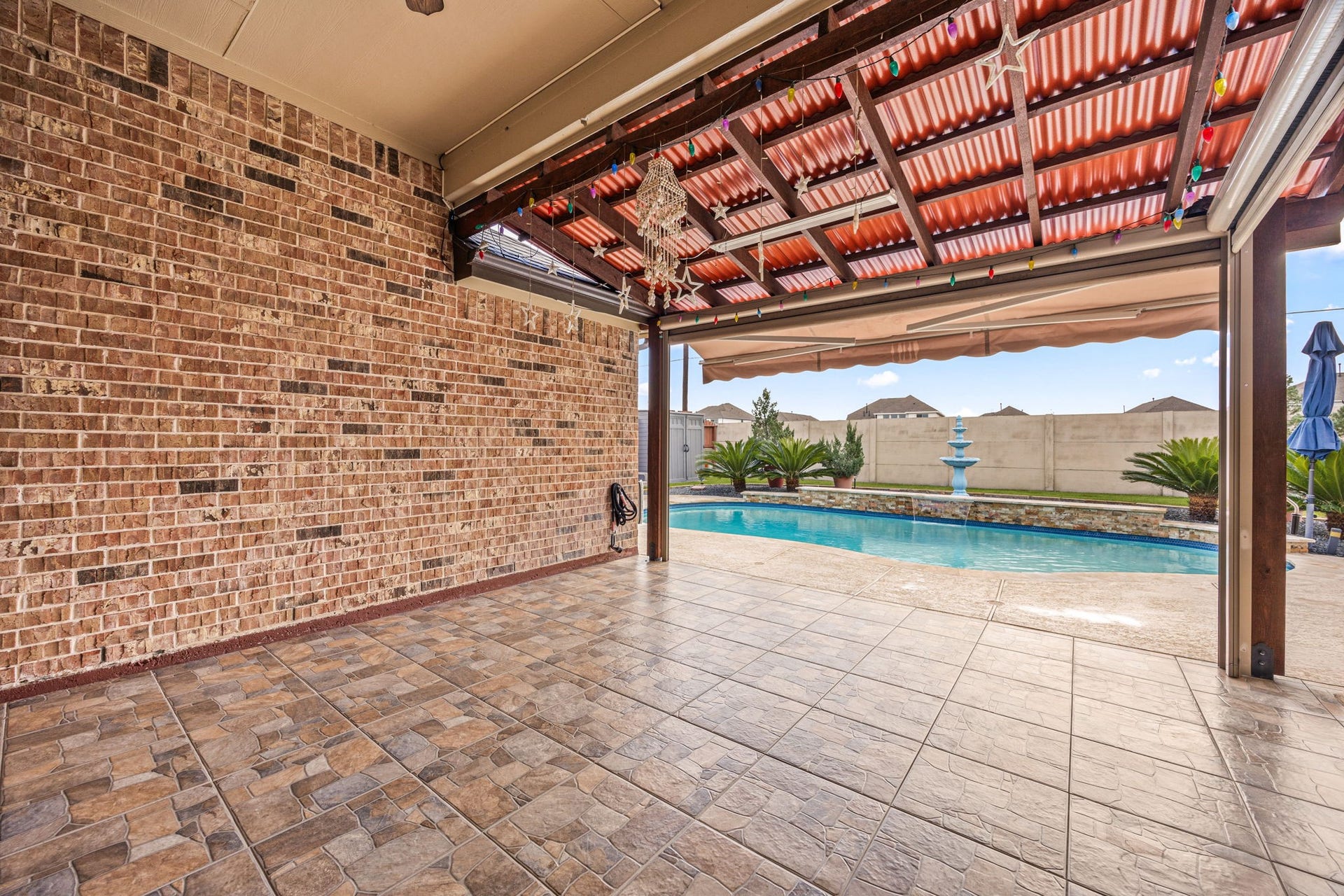 An incredible first impression as you step outside! A massive covered patio with premium tile flooring opens up to your own private backyard oasis, complete with a sparkling in-ground pool.