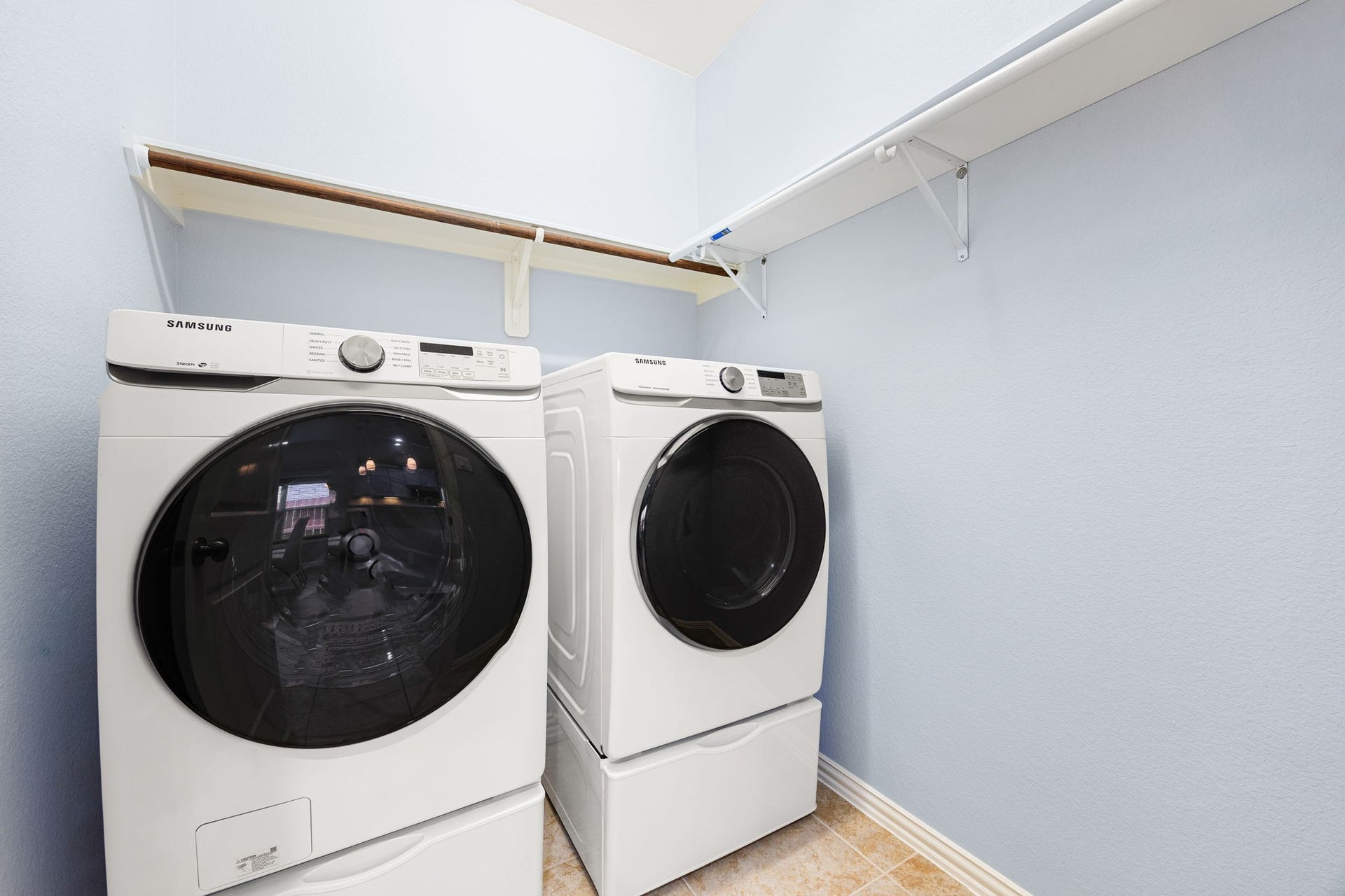 A dedicated laundry space designed for efficiency, featuring ample overhead storage space and practical shelving options.