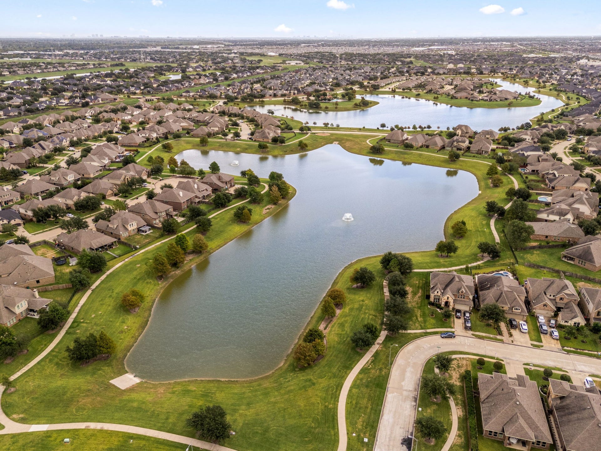 This stunning view showcases the neighborhood's expansive lakes and paved walking trails, situated just minutes away from the community clubhouse, pools, and prime shopping and dining centers.