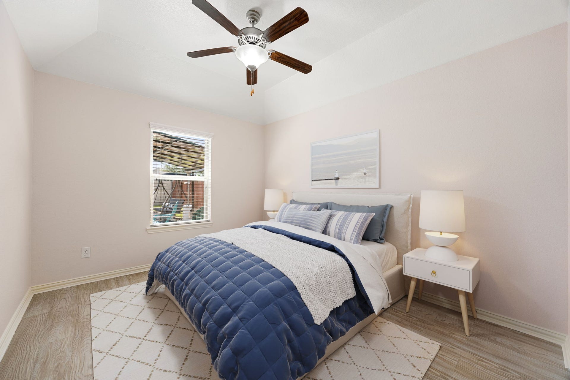 Another beautifully appointed secondary bedroom, showcasing an elegant tray ceiling, ceiling fan, wood-look flooring, and a bright window overlooking the backyard patio. *Virtually Staged