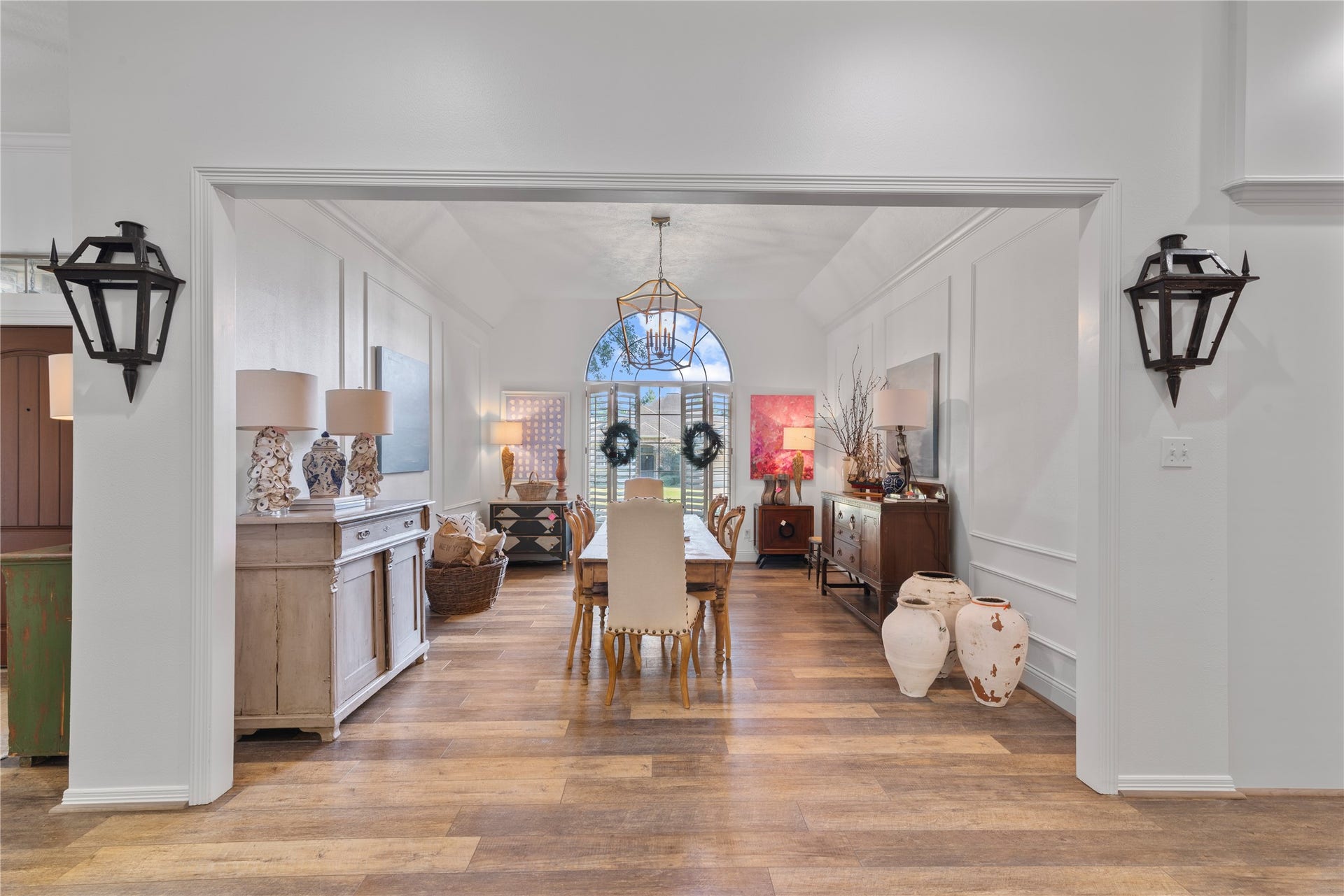 901 Longmire Road, #51, Conroe, TX 77304 An elegant formal dining room featuring timeless architectural detailing, sophisticated lighting, beautiful wood flooring & a stunning arched window that fills the space with natural light.