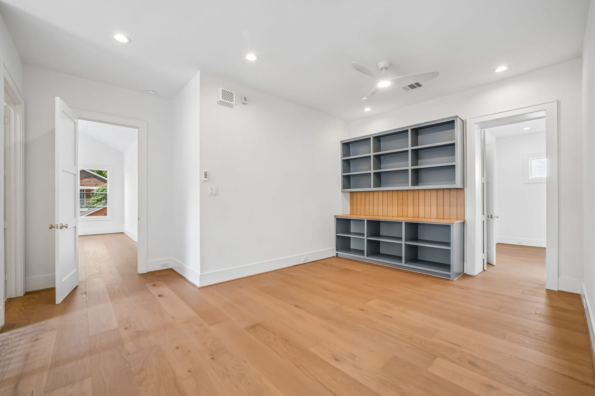 Second-floor loft featuring custom built-in storage with refined white oak finishes.